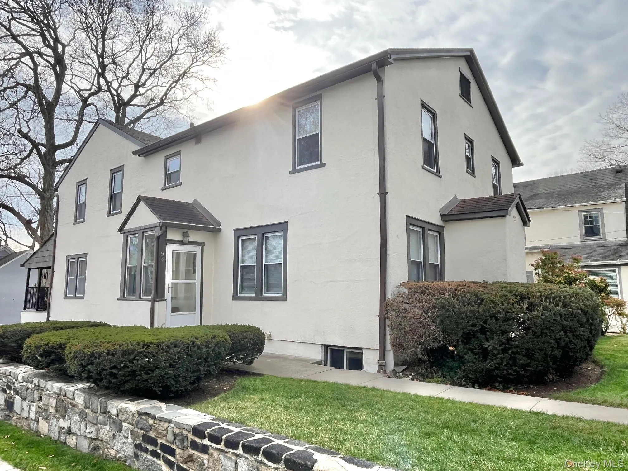View of front of home featuring stucco siding and a front yard View of front of home featuring stucco siding and a front yard