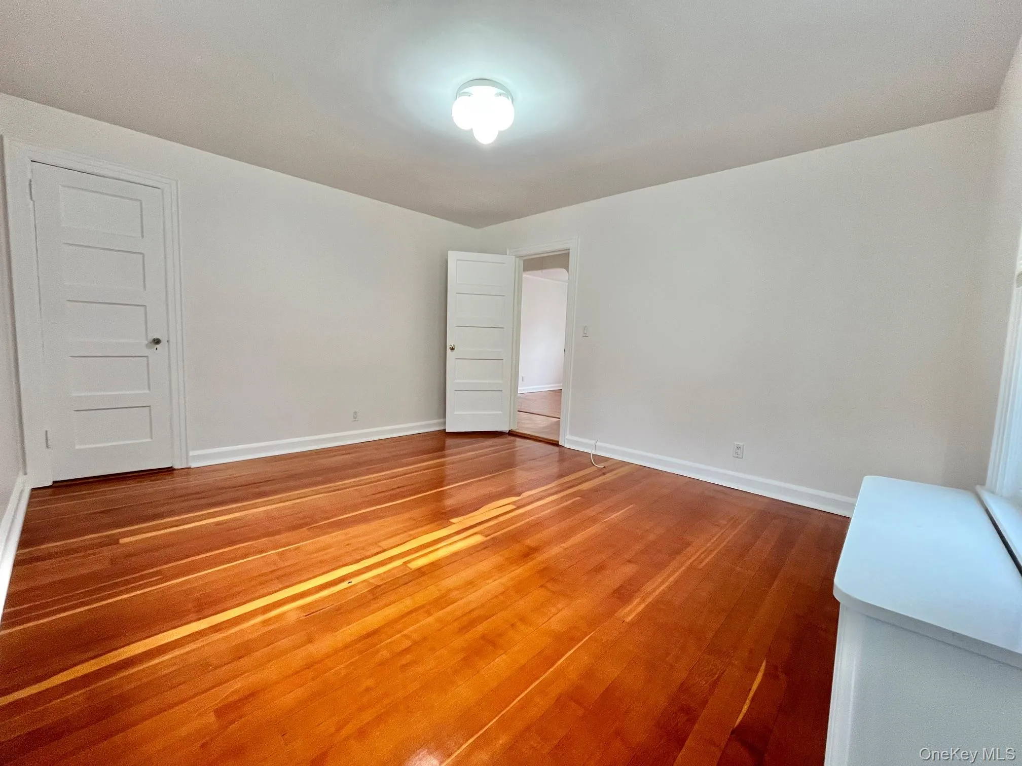 Spare room with light wood-style floors and baseboards Spare room with light wood-style floors and baseboards