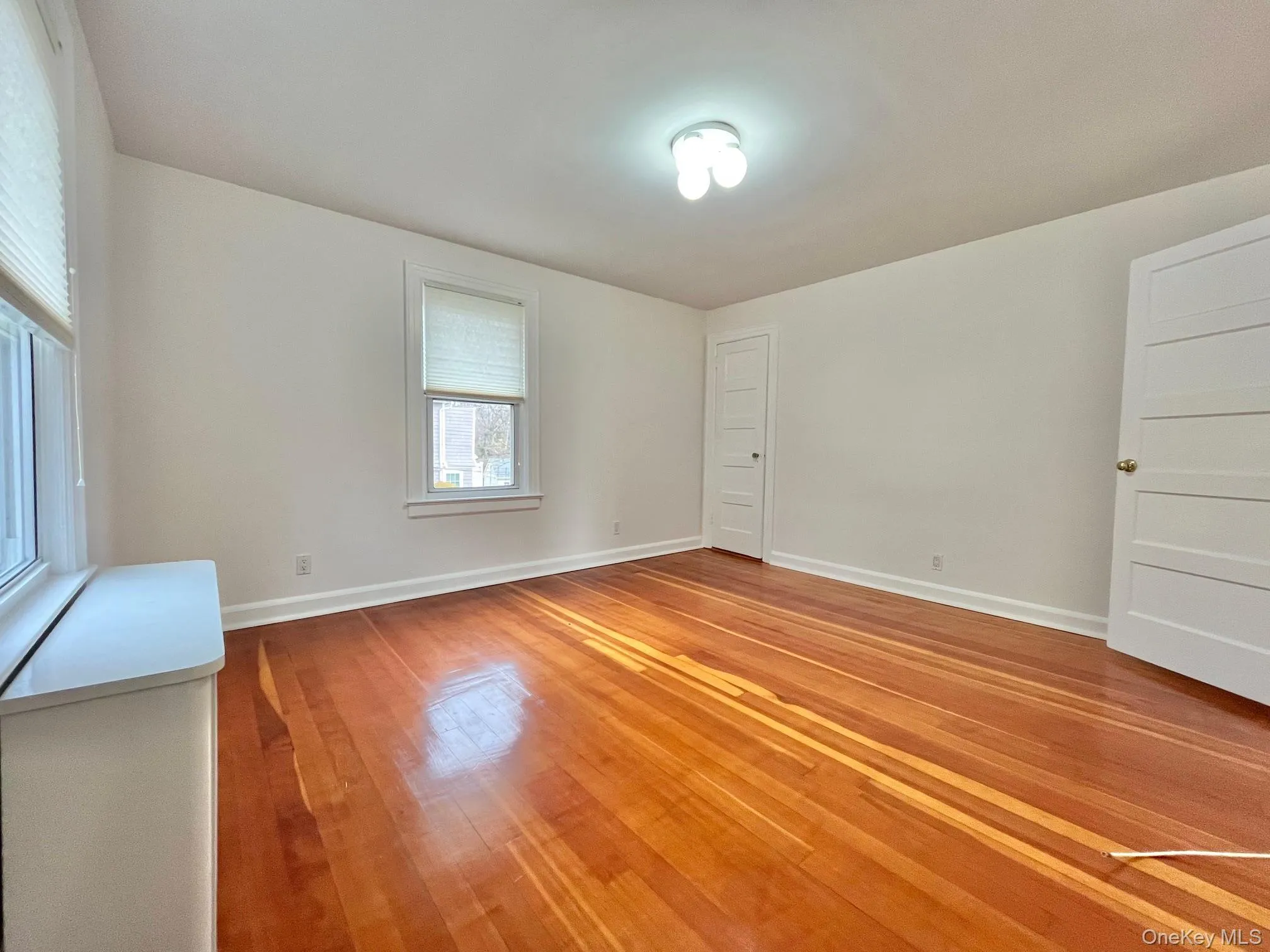 Unfurnished room featuring light wood-style flooring and baseboards Unfurnished room featuring light wood-style flooring and baseboards