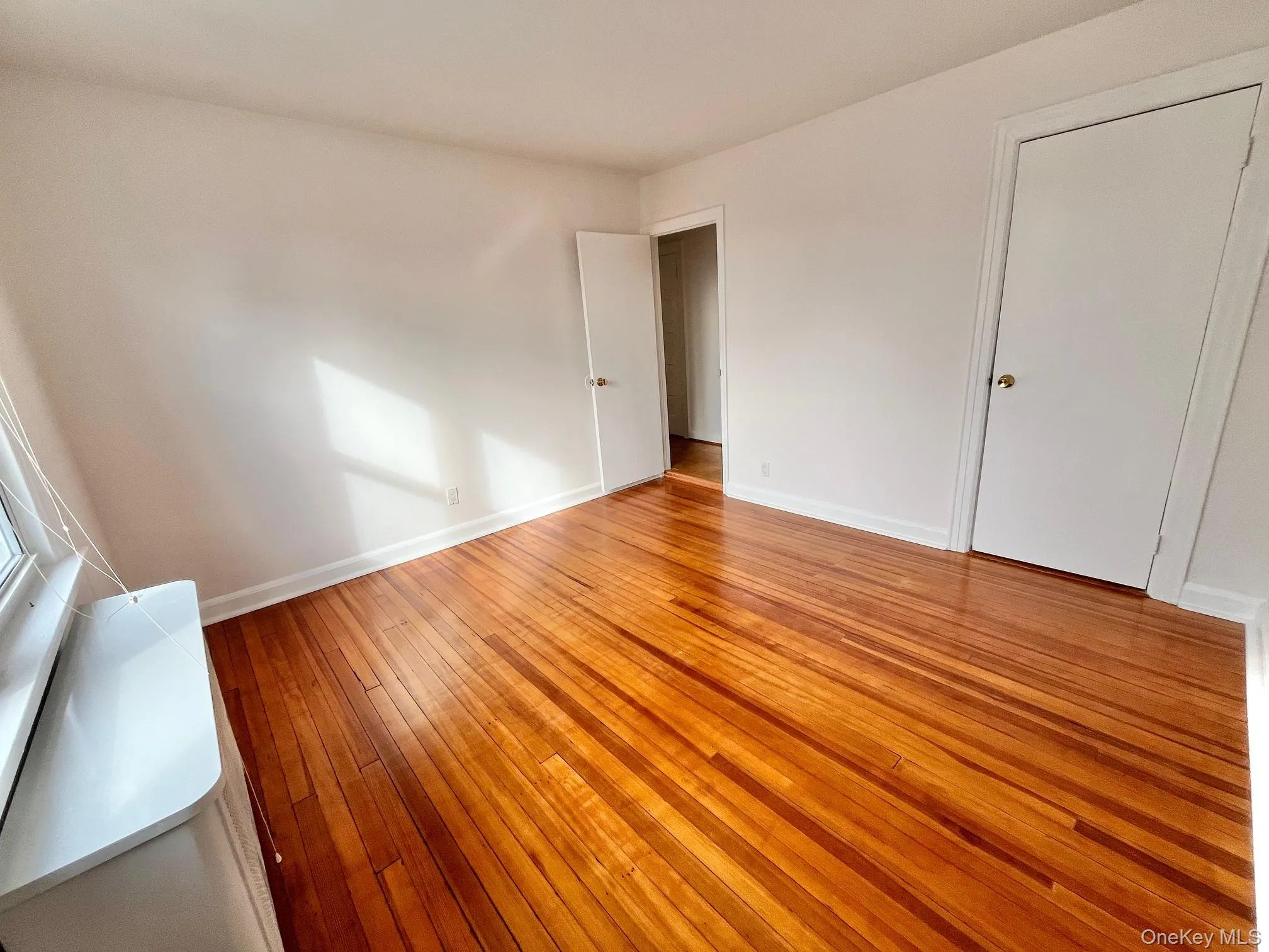 Unfurnished bedroom featuring light wood-style floors and baseboards Unfurnished bedroom featuring light wood-style floors and baseboards