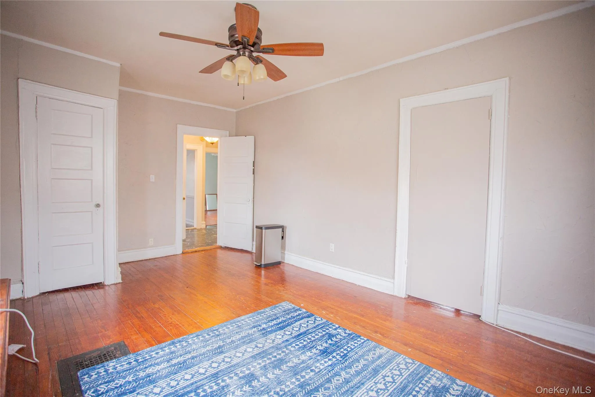 Unfurnished bedroom featuring crown molding, light wood finished floors, and a ceiling fan Unfurnished bedroom featuring crown molding, light wood finished floors, and a ceiling fan