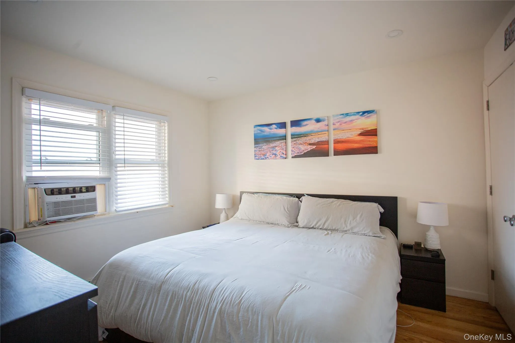 Bedroom with cooling unit and wood finished floors Bedroom with cooling unit and wood finished floors