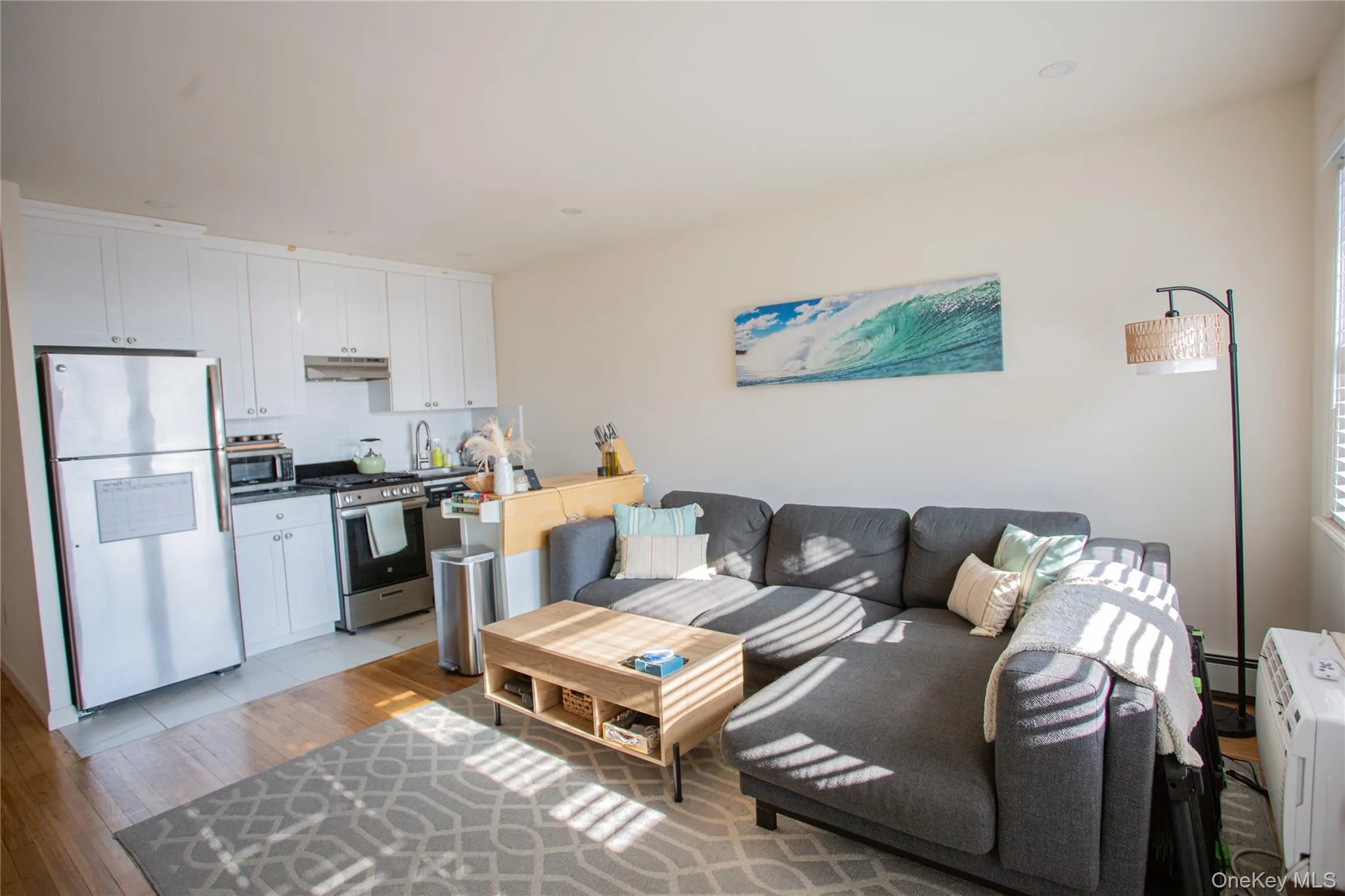 Living area featuring light wood-style floors and a baseboard heating unit Living area featuring light wood-style floors and a baseboard heating unit