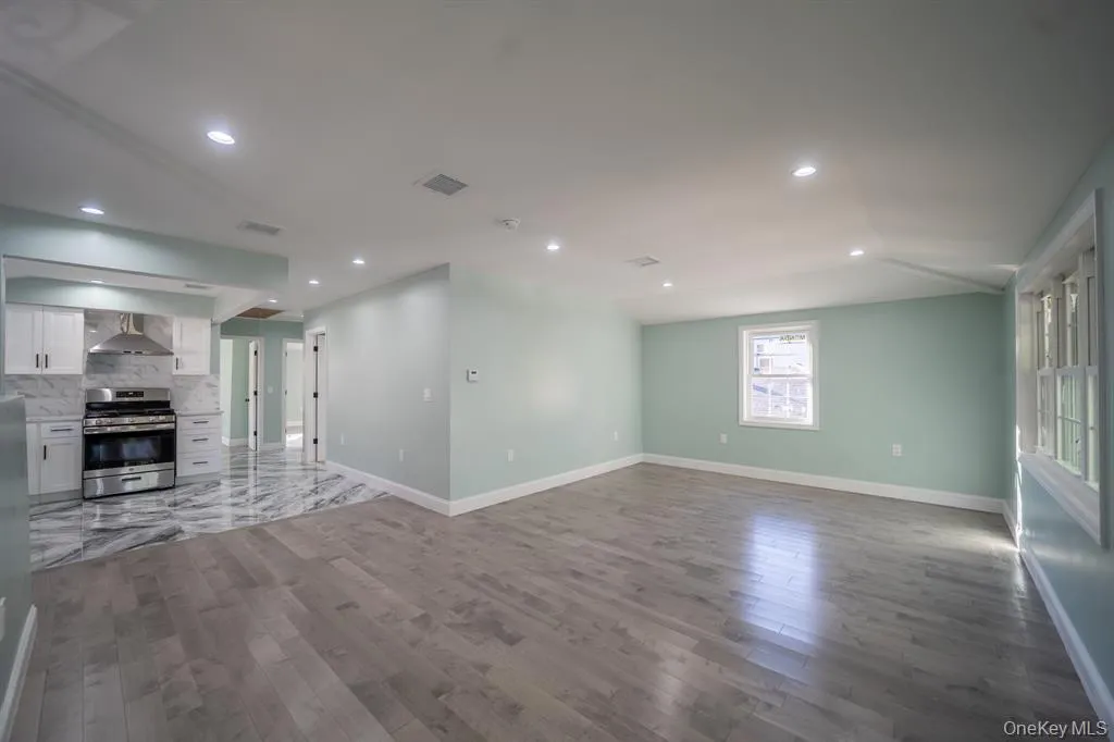 Unfurnished living room featuring recessed lighting, dark wood-type flooring, and lofted ceiling Unfurnished living room featuring recessed lighting, dark wood-type flooring, and lofted ceiling