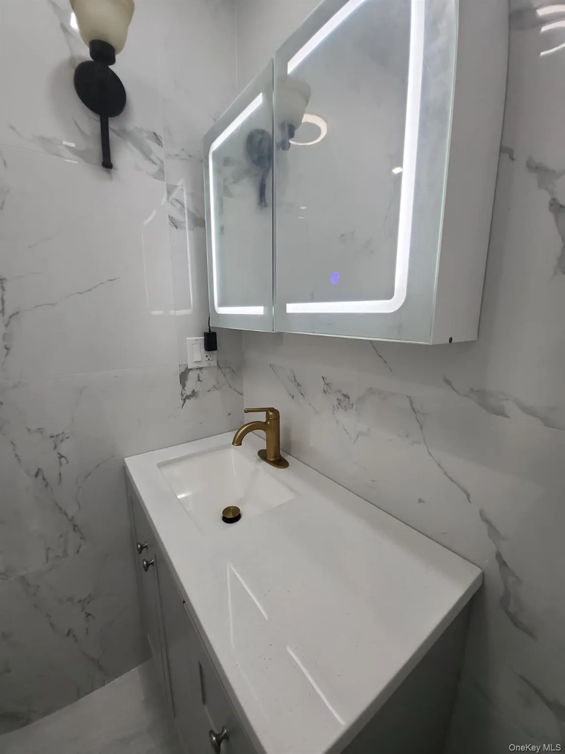 Bathroom featuring vanity and stone wall Bathroom featuring vanity and stone wall