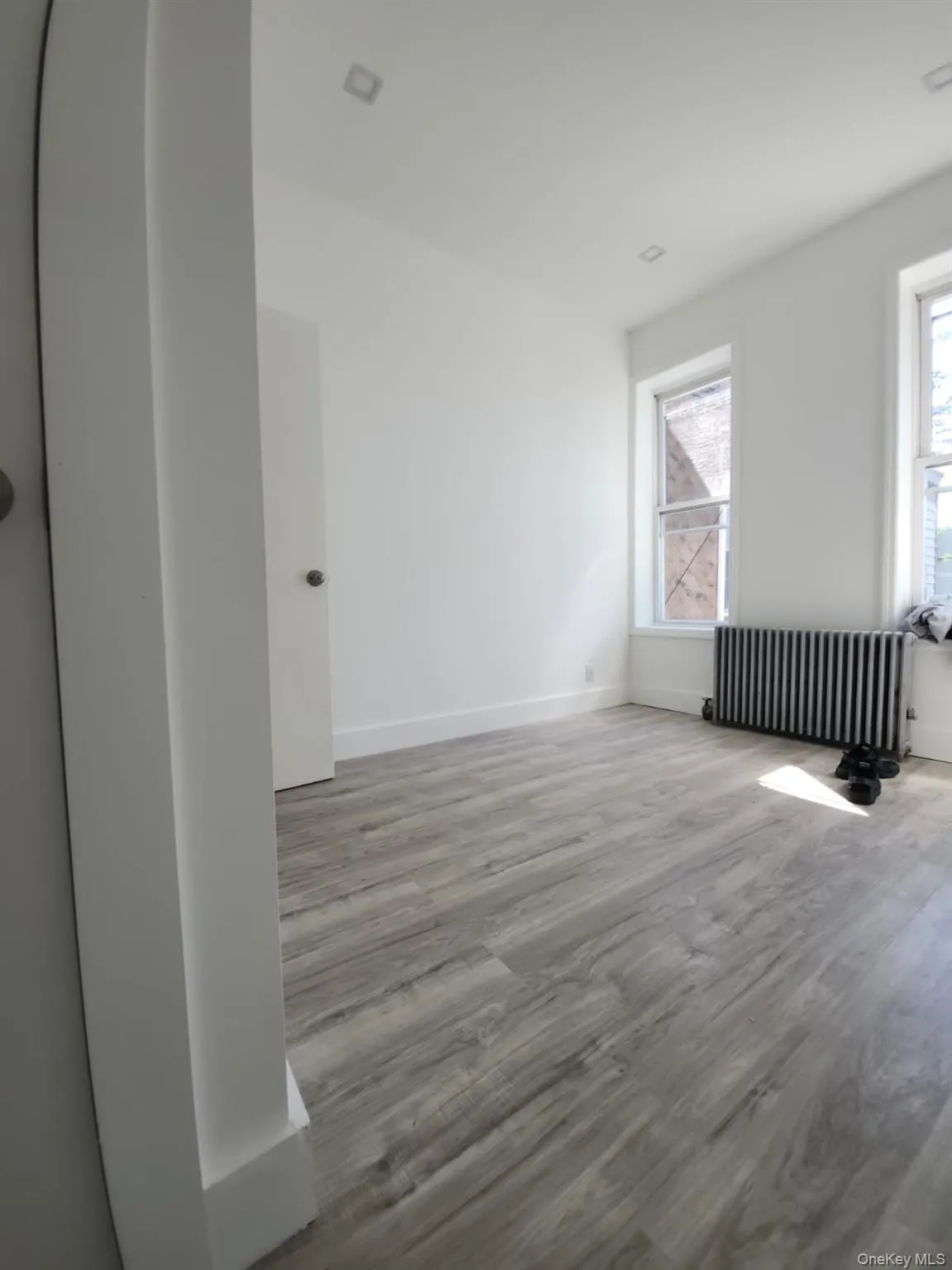 Spare room with radiator and wood finished floors Spare room with radiator and wood finished floors