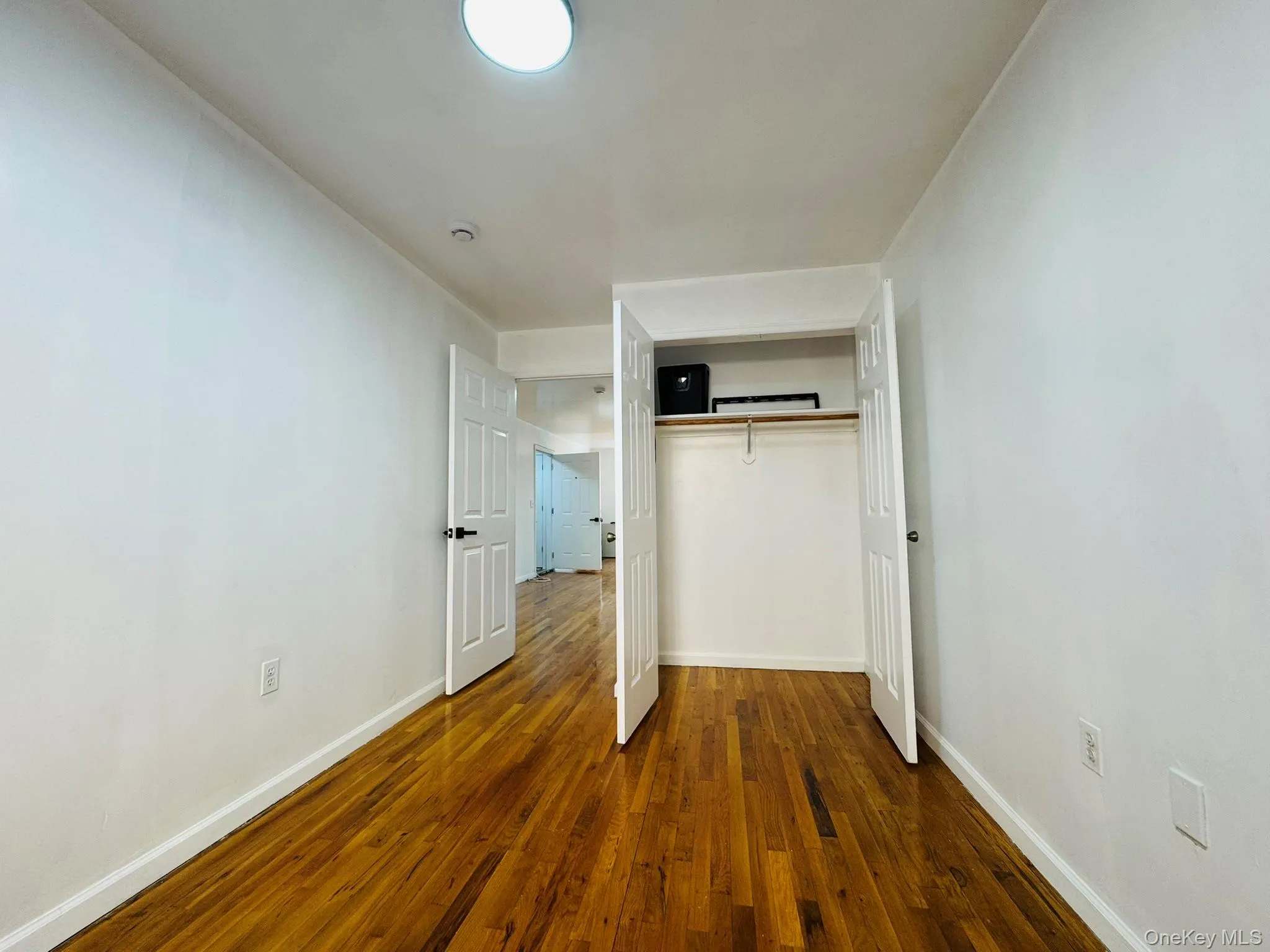 Unfurnished bedroom featuring dark wood finished floors and a closet Unfurnished bedroom featuring dark wood finished floors and a closet