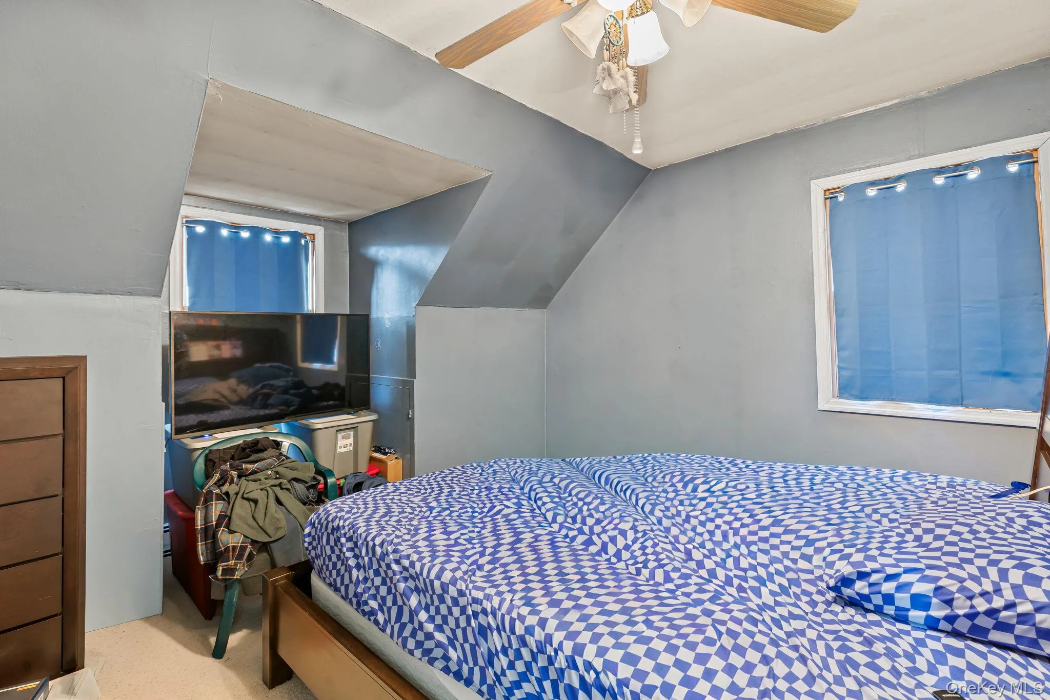 Carpeted bedroom with lofted ceiling and a ceiling fan Carpeted bedroom with lofted ceiling and a ceiling fan