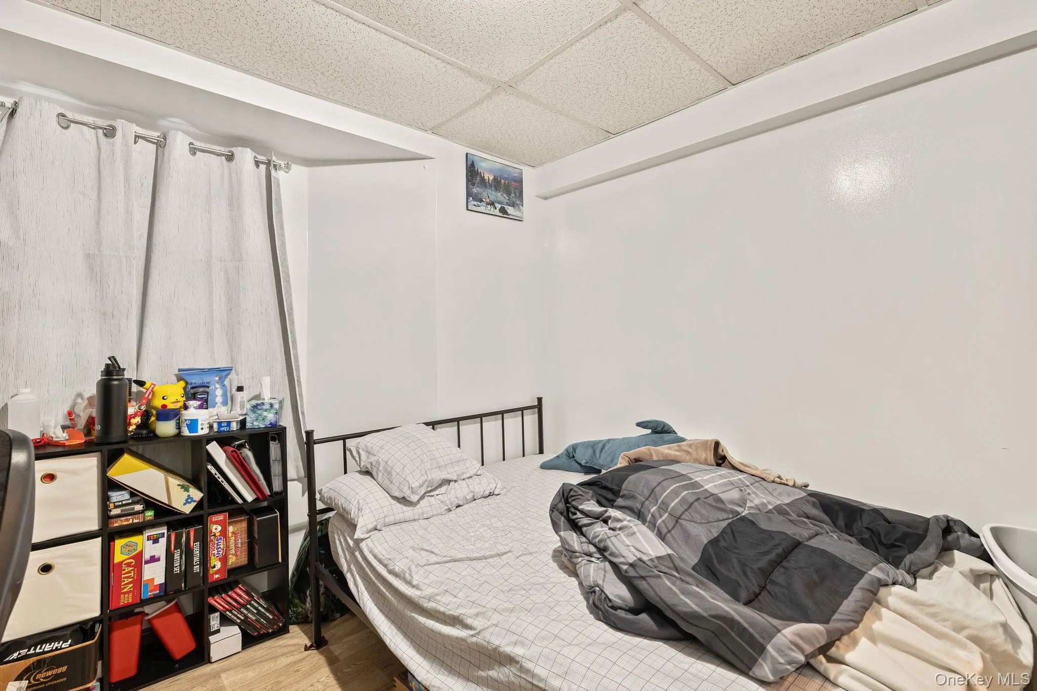 Bedroom featuring a paneled ceiling and wood finished floors Bedroom featuring a paneled ceiling and wood finished floors