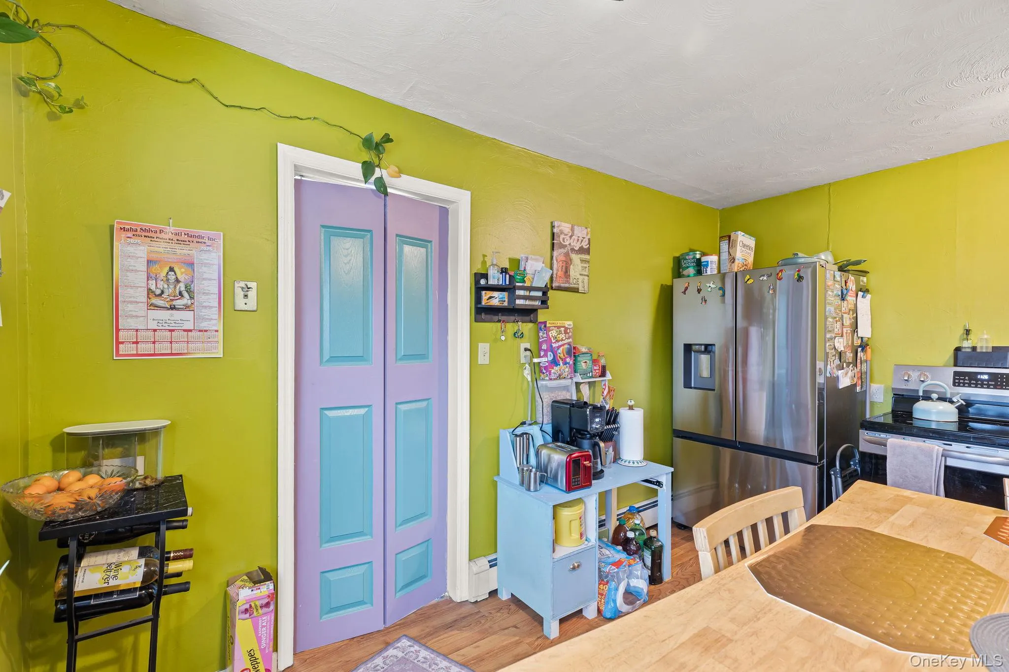 Kitchen featuring stainless steel appliances, wood finished floors, and a baseboard radiator Kitchen featuring stainless steel appliances, wood finished floors, and a baseboard radiator