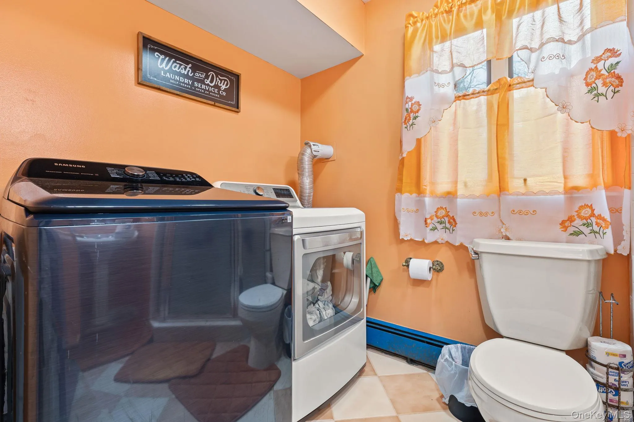 Half bathroom featuring toilet and washer and dryer Half bathroom featuring toilet and washer and dryer