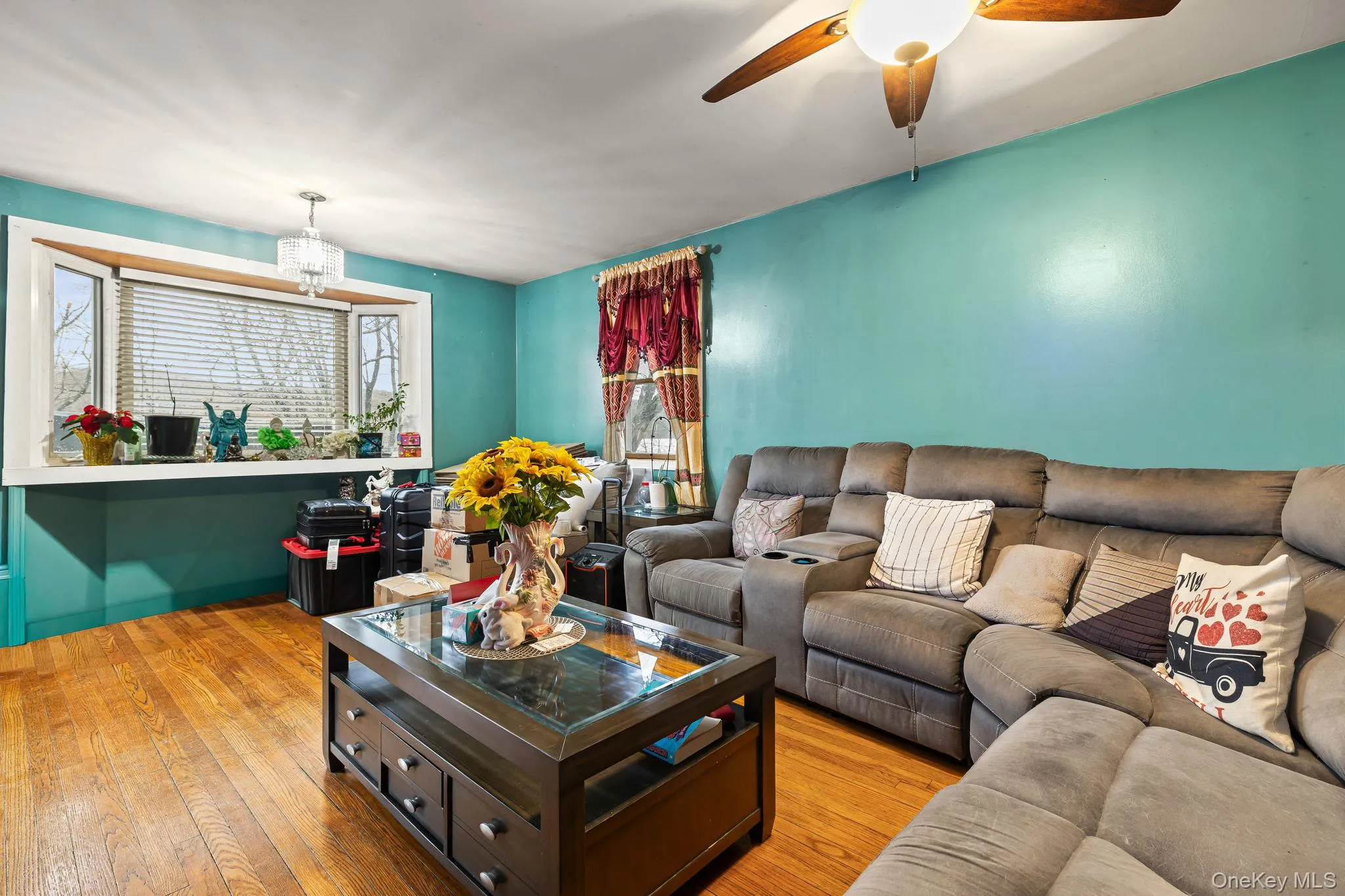 Living area featuring hardwood / wood-style floors, ceiling fan, and a chandelier Living area featuring hardwood / wood-style floors, ceiling fan, and a chandelier