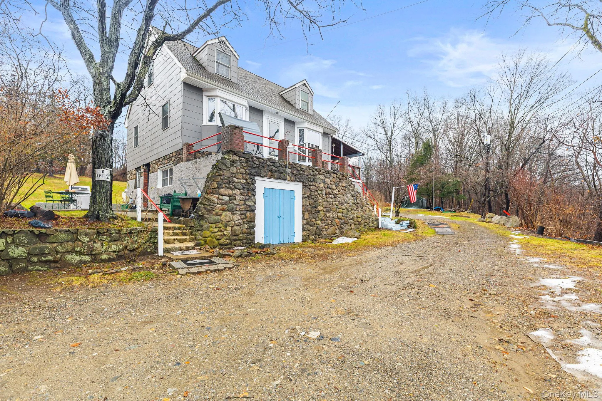 View of side of home with stairway, a balcony, and stone siding View of side of home with stairway, a balcony, and stone siding