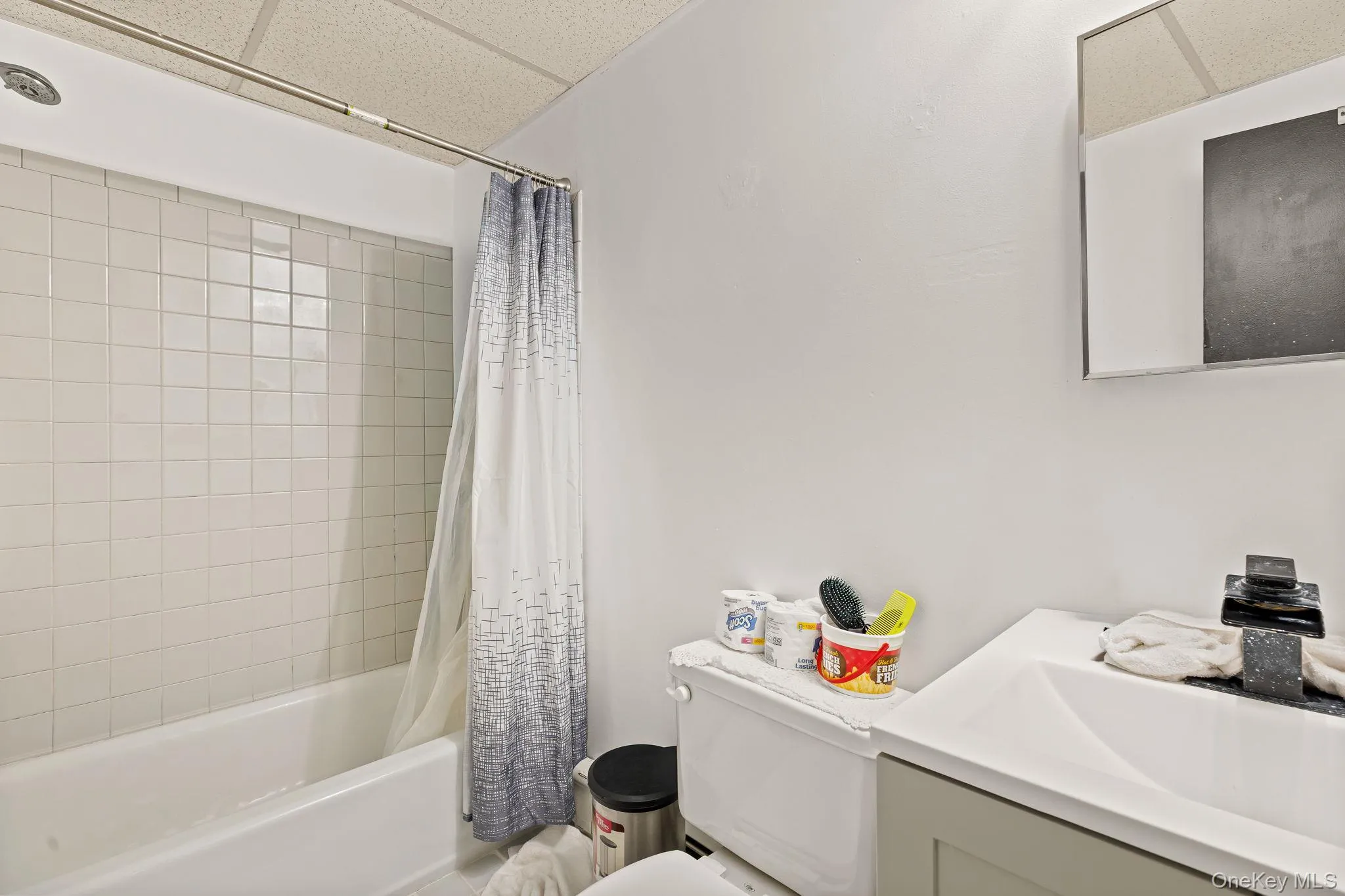Full bath featuring shower / bath combo, a drop ceiling, and vanity Full bath featuring shower / bath combo, a drop ceiling, and vanity