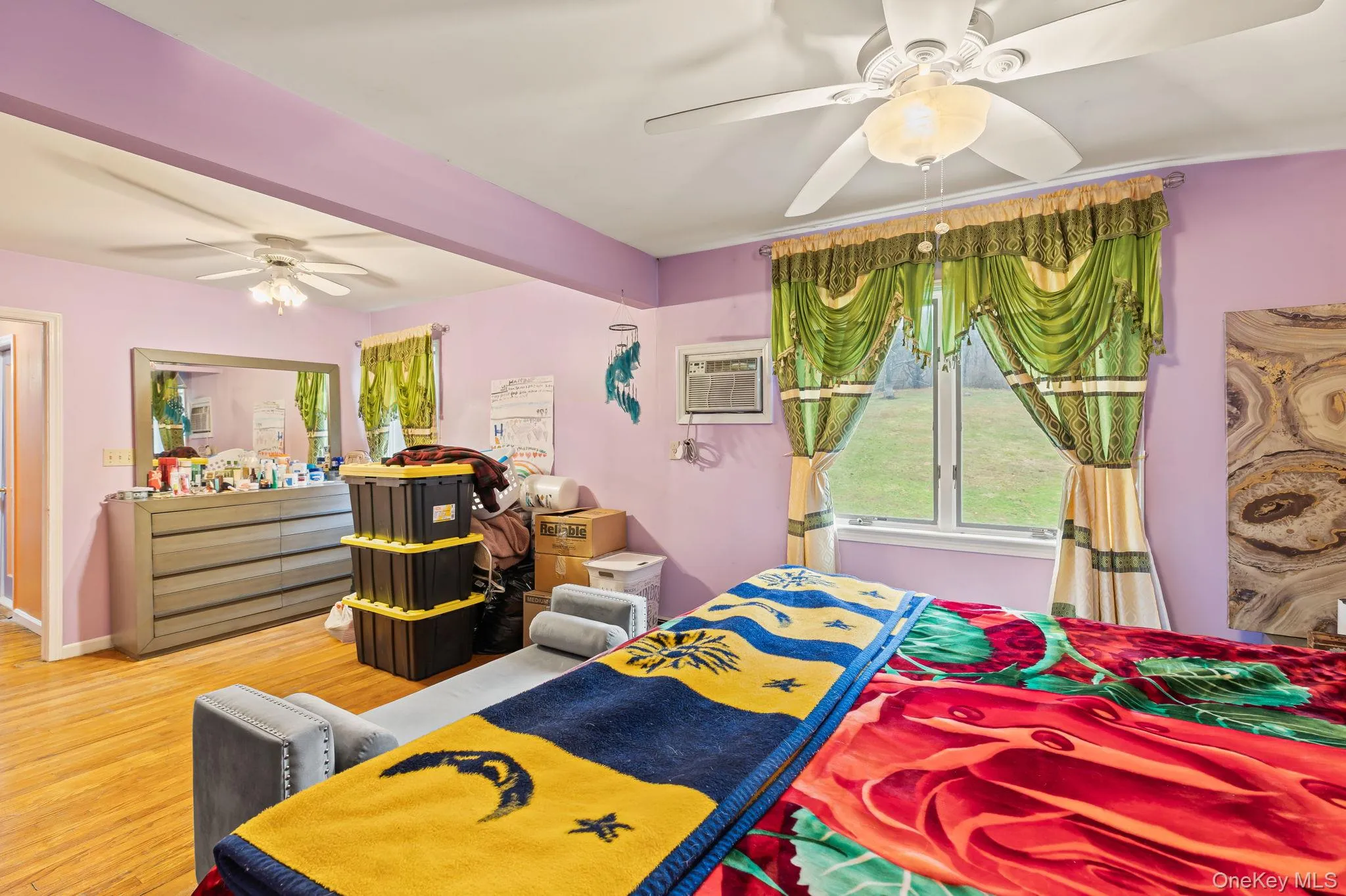Bedroom with ceiling fan, wood finished floors, and a wall mounted AC Bedroom with ceiling fan, wood finished floors, and a wall mounted AC