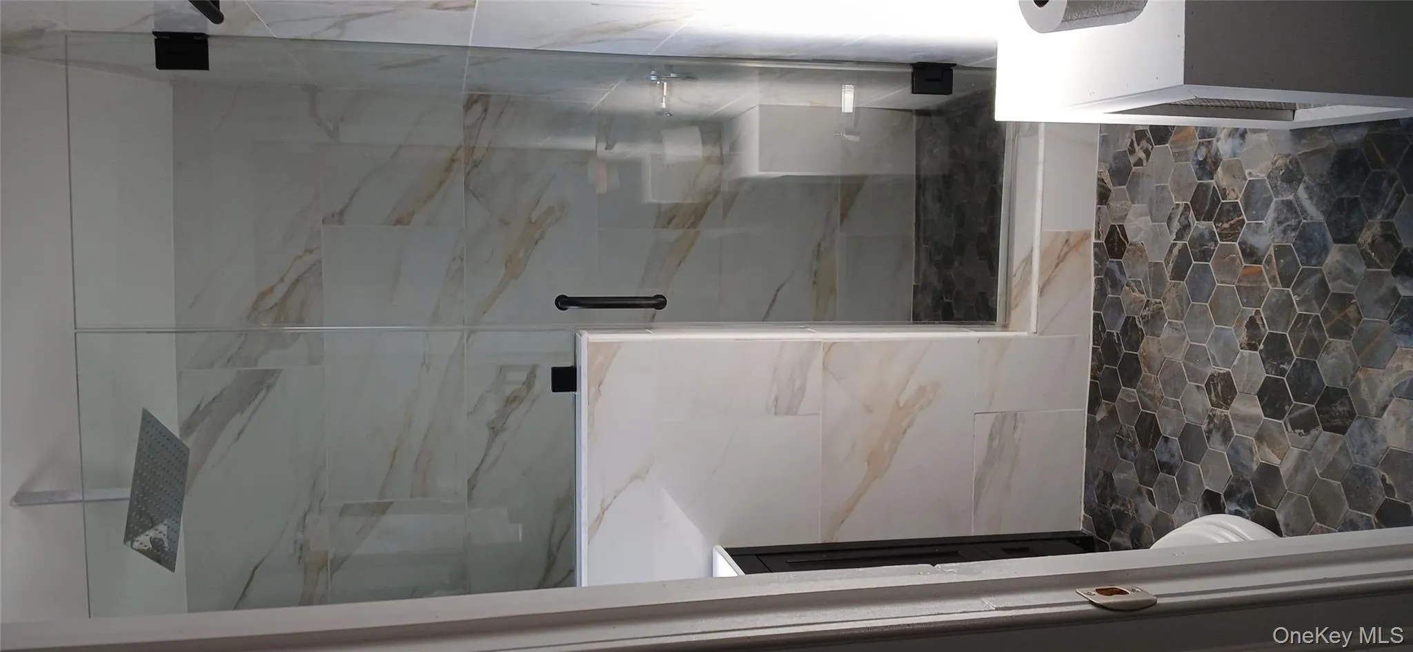 Bathroom with vanity, a marble finish shower, and dark stone finish flooring Bathroom with vanity, a marble finish shower, and dark stone finish flooring