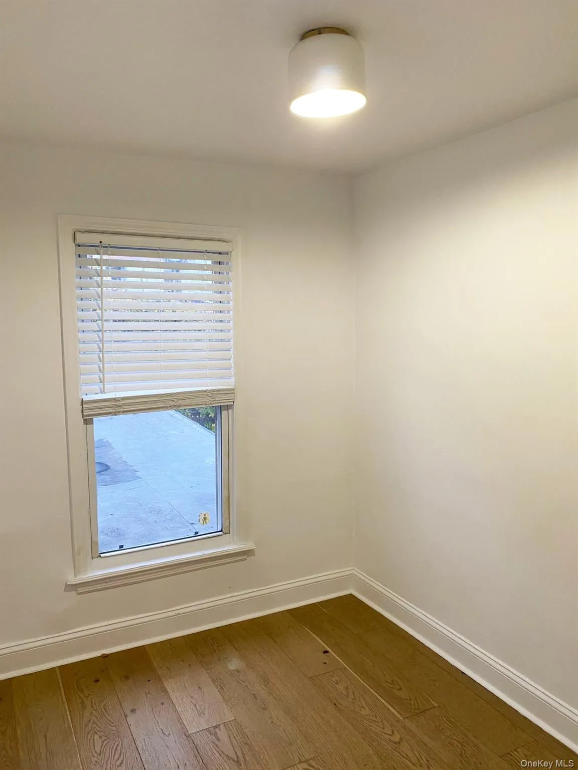 Spare room with baseboards and dark wood-type flooring Spare room with baseboards and dark wood-type flooring