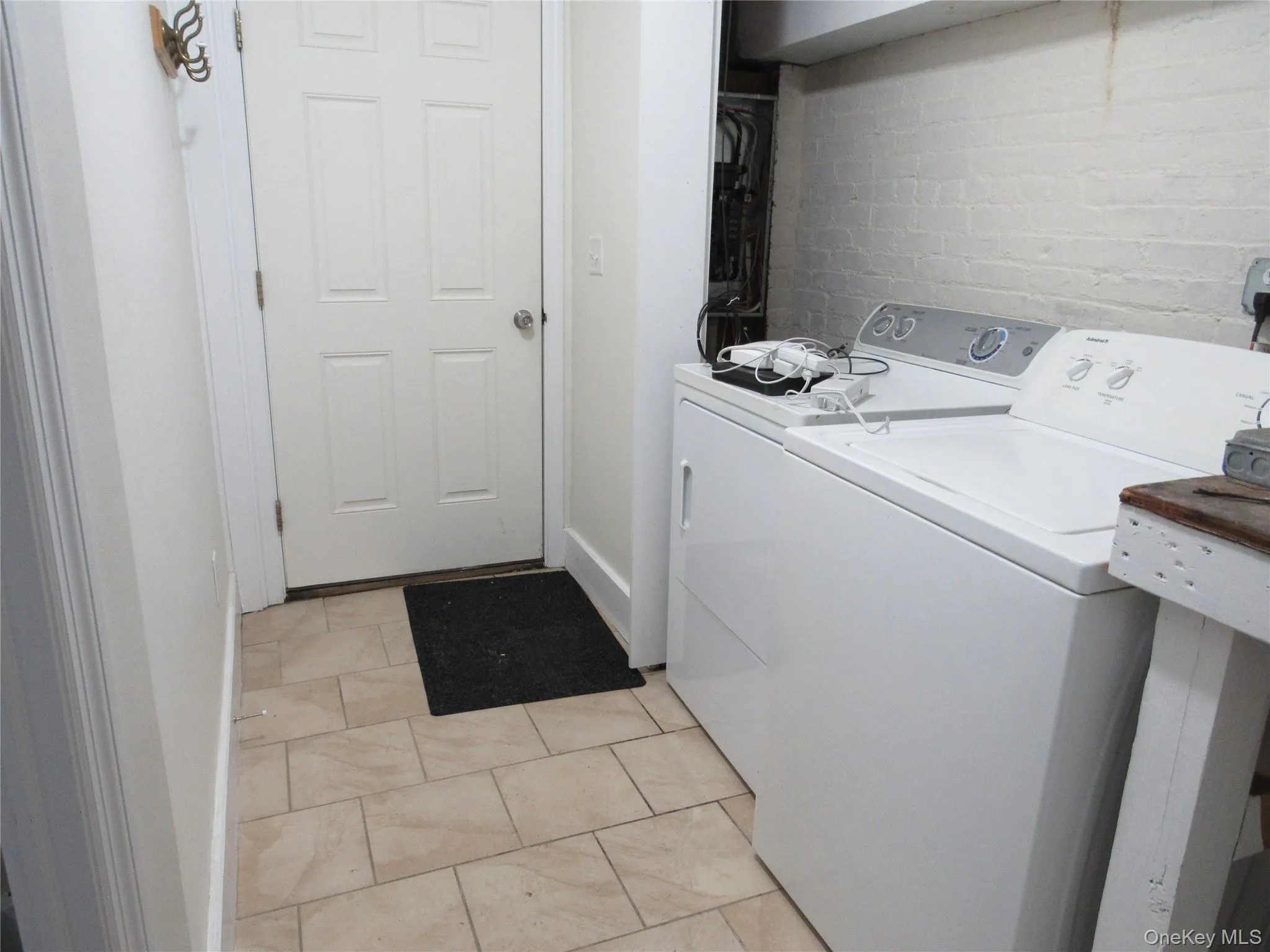 Laundry area featuring brick wall and independent washer and dryer Laundry area featuring brick wall and independent washer and dryer