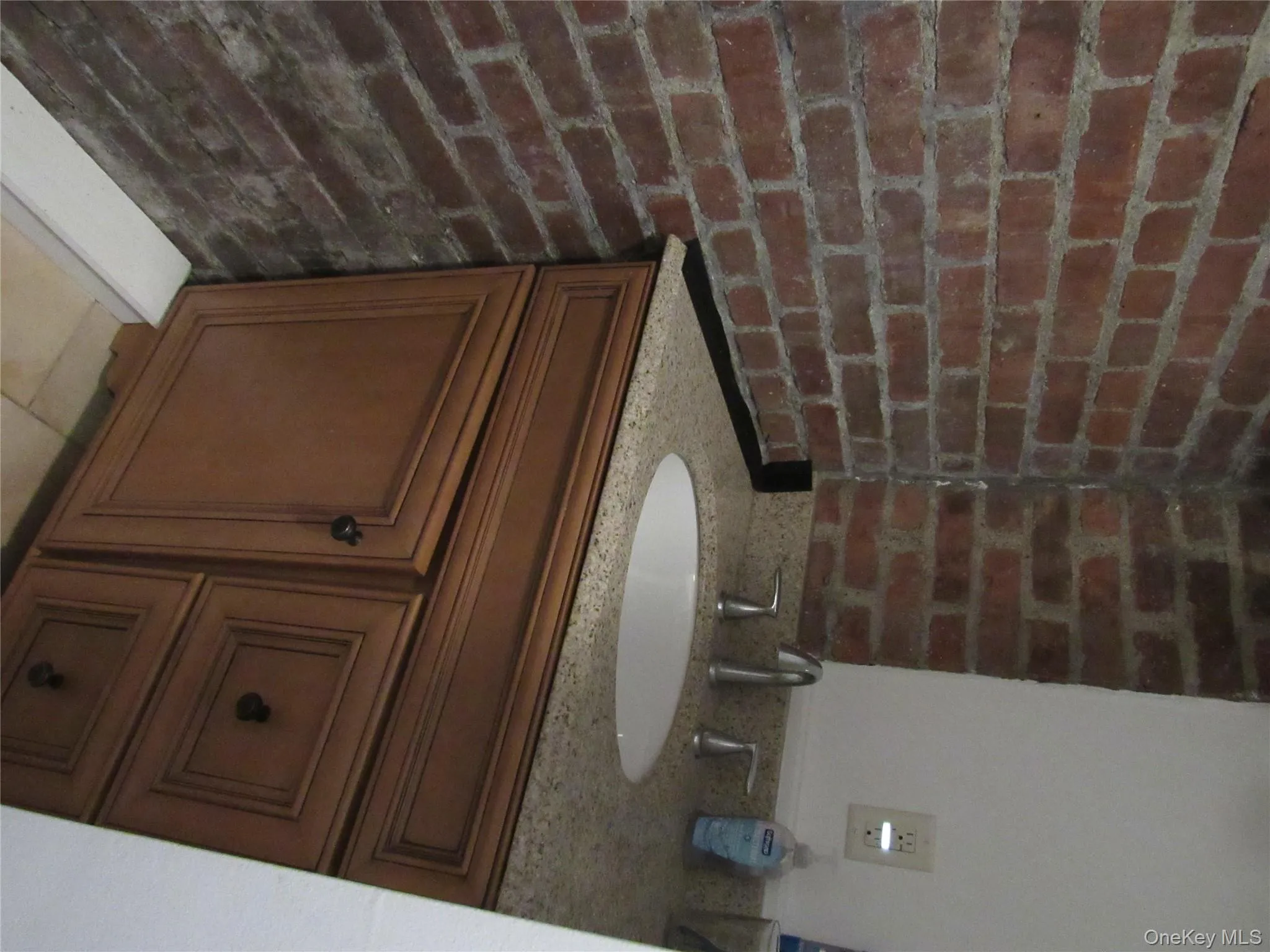 Bathroom with brick wall and vanity Bathroom with brick wall and vanity