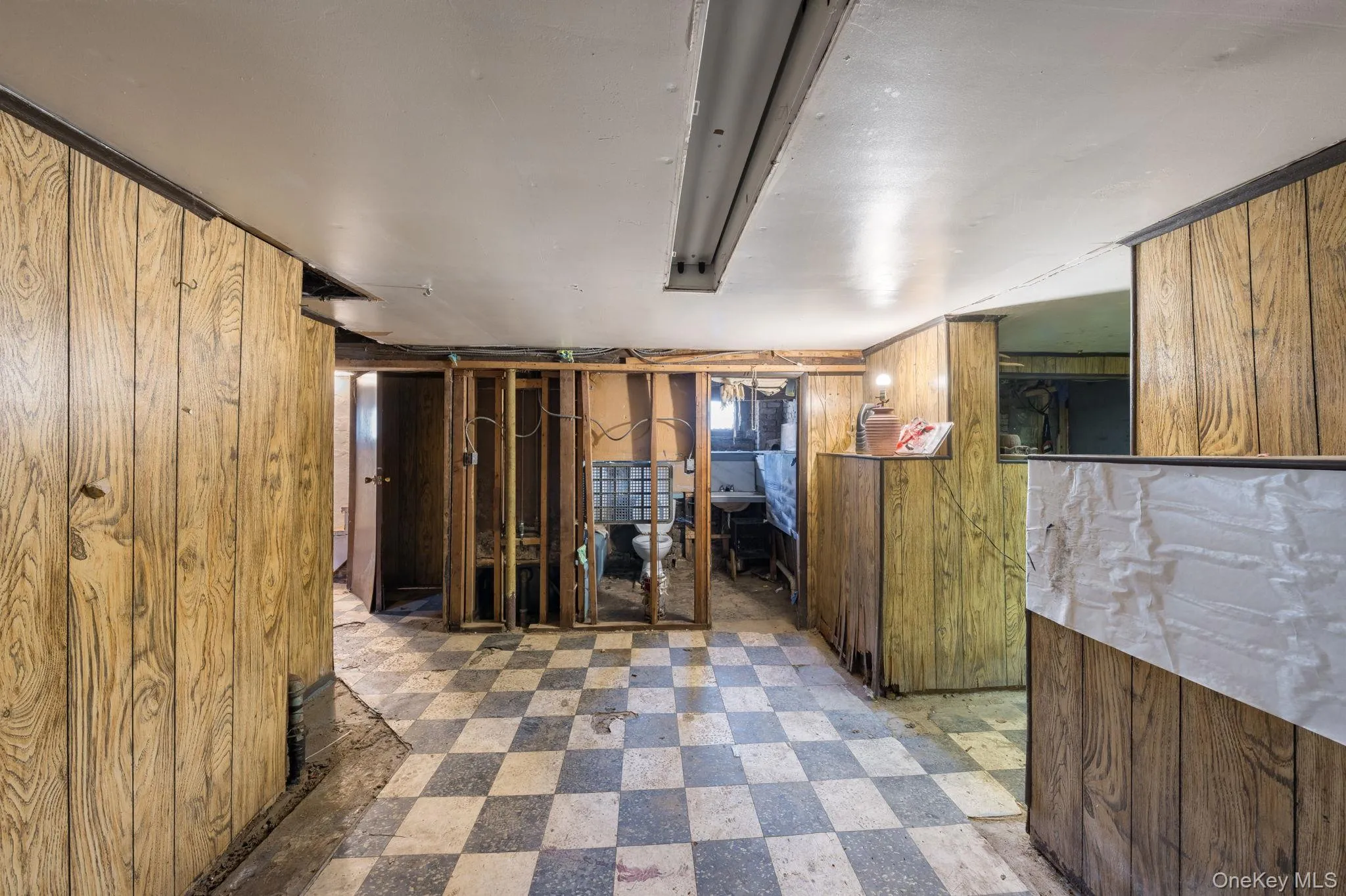 Below grade area with light floors and wooden walls Below grade area with light floors and wooden walls