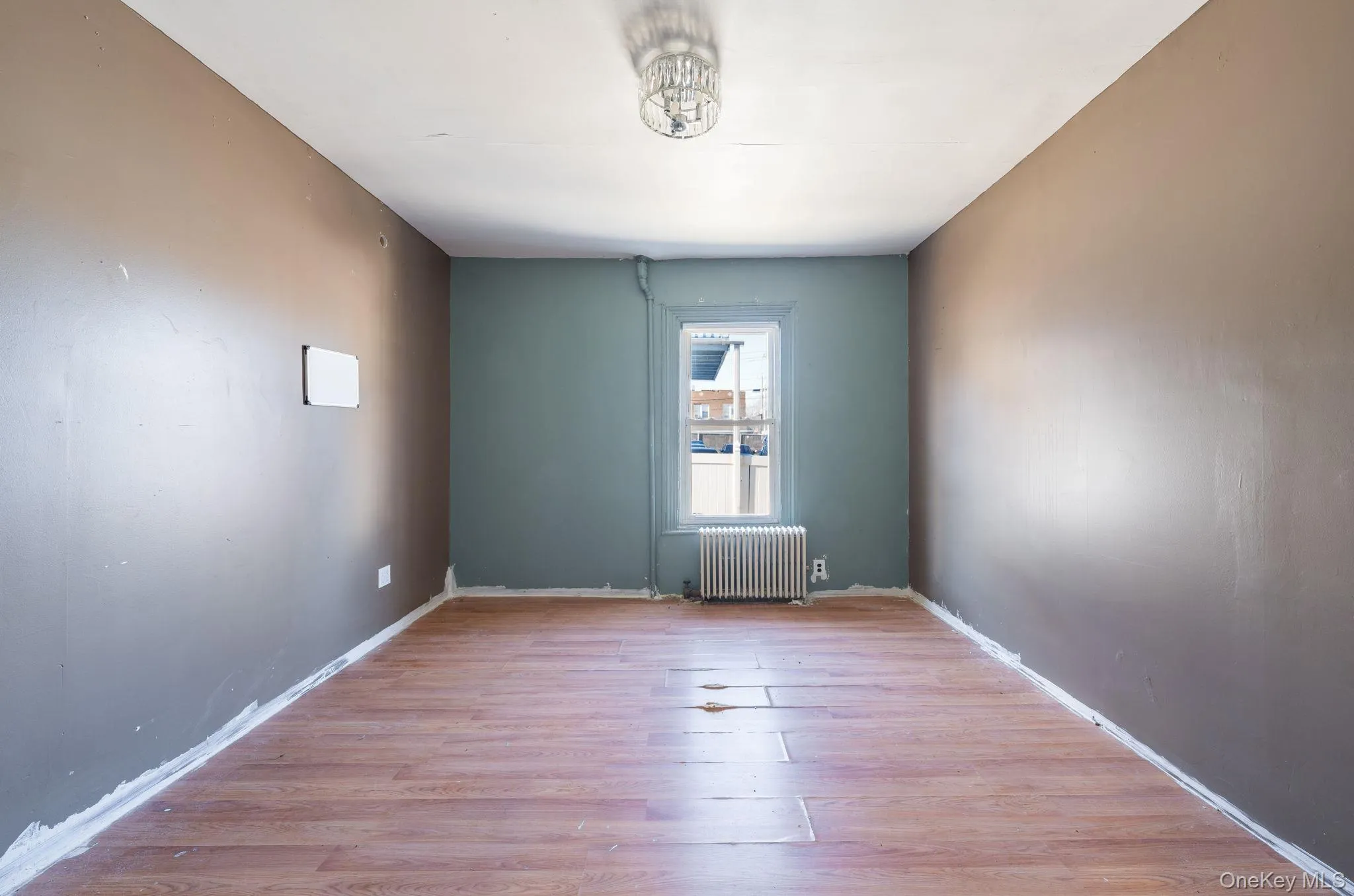 Unfurnished room with light wood-style floors and radiator heating unit Unfurnished room with light wood-style floors and radiator heating unit