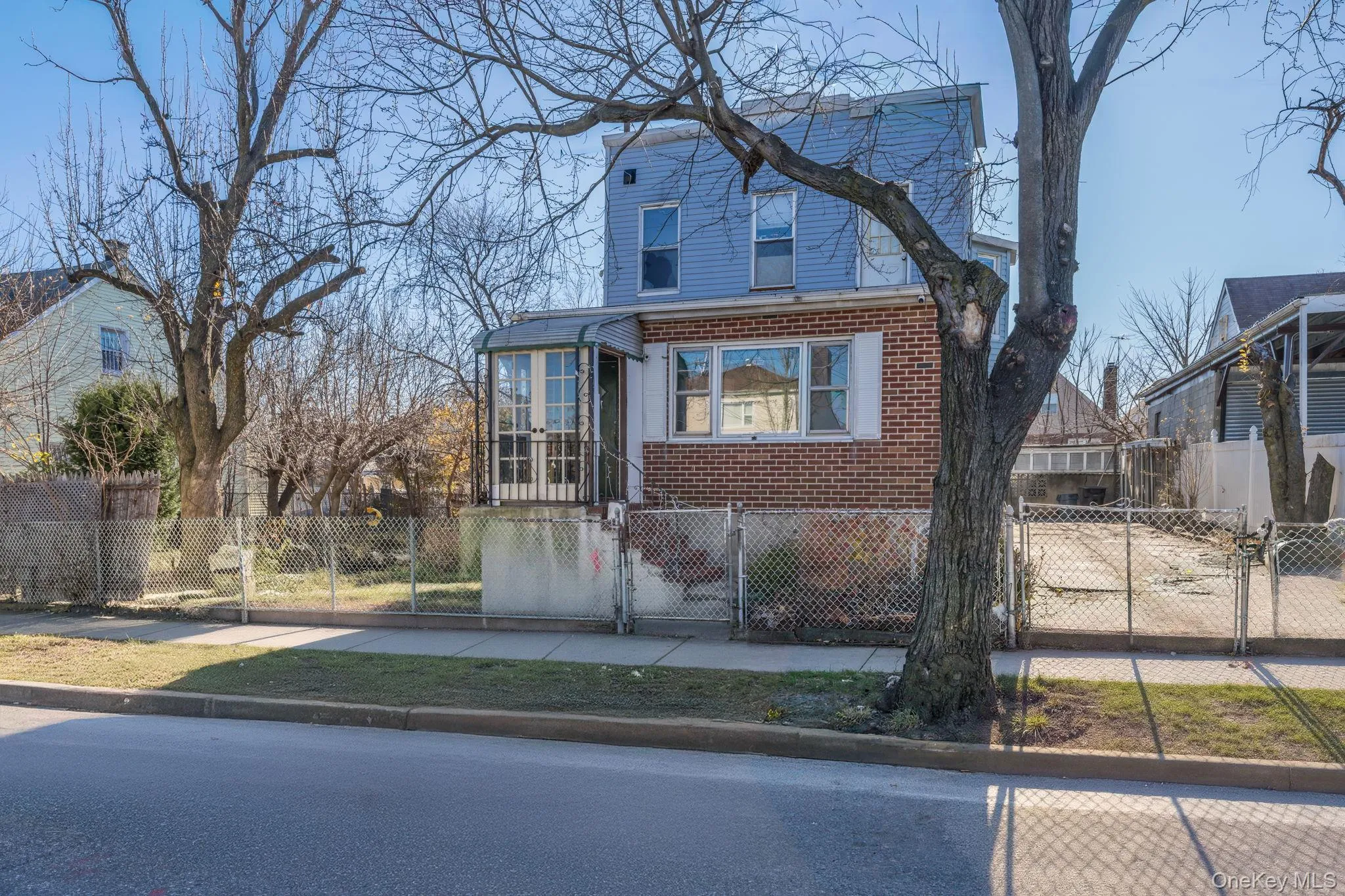 View of front of home with brick siding, a gate, and a fenced front yard View of front of home with brick siding, a gate, and a fenced front yard