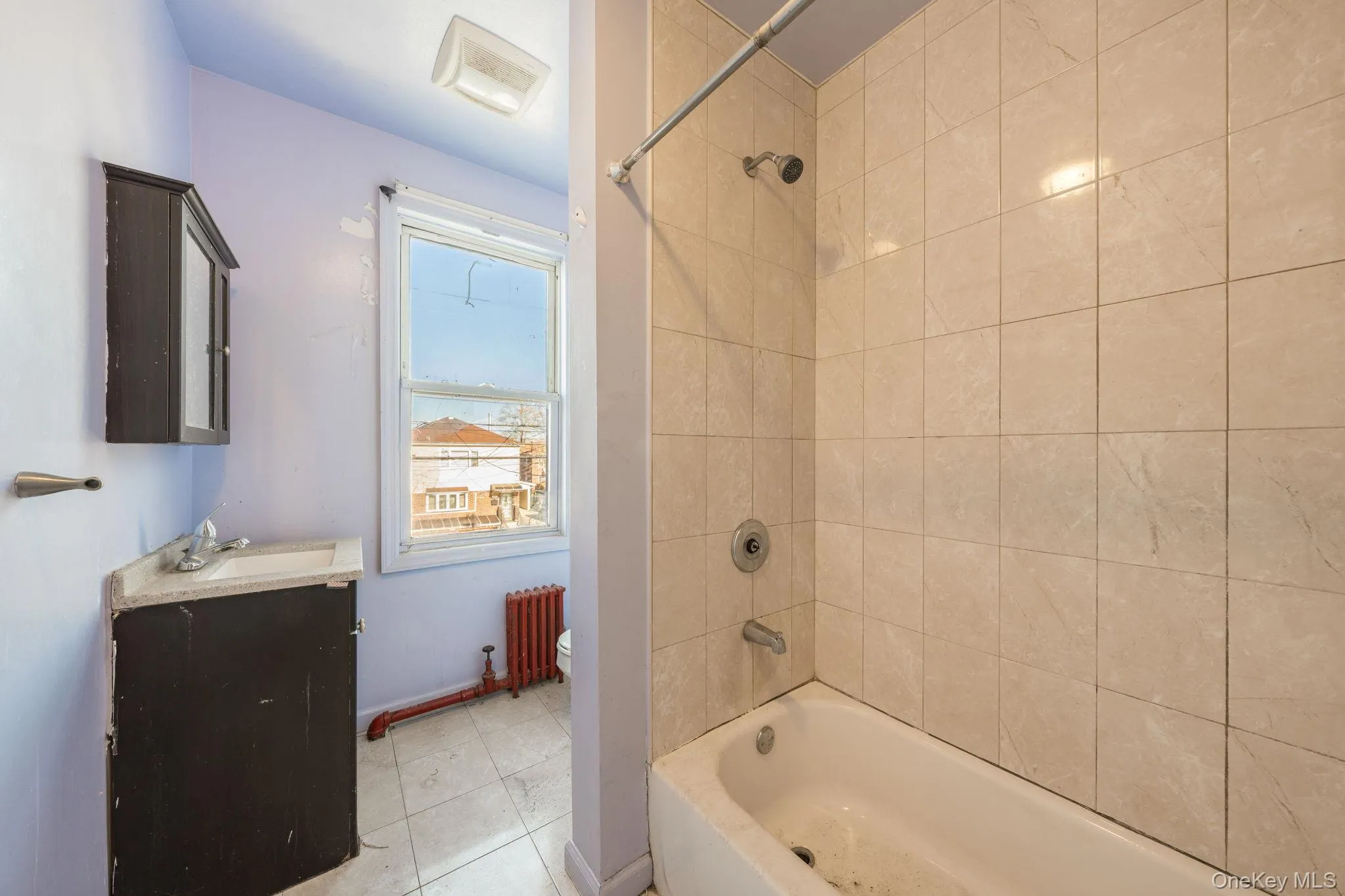 Full bathroom with vanity, radiator, shower / tub combination, and light tile patterned flooring Full bathroom with vanity, radiator, shower / tub combination, and light tile patterned flooring