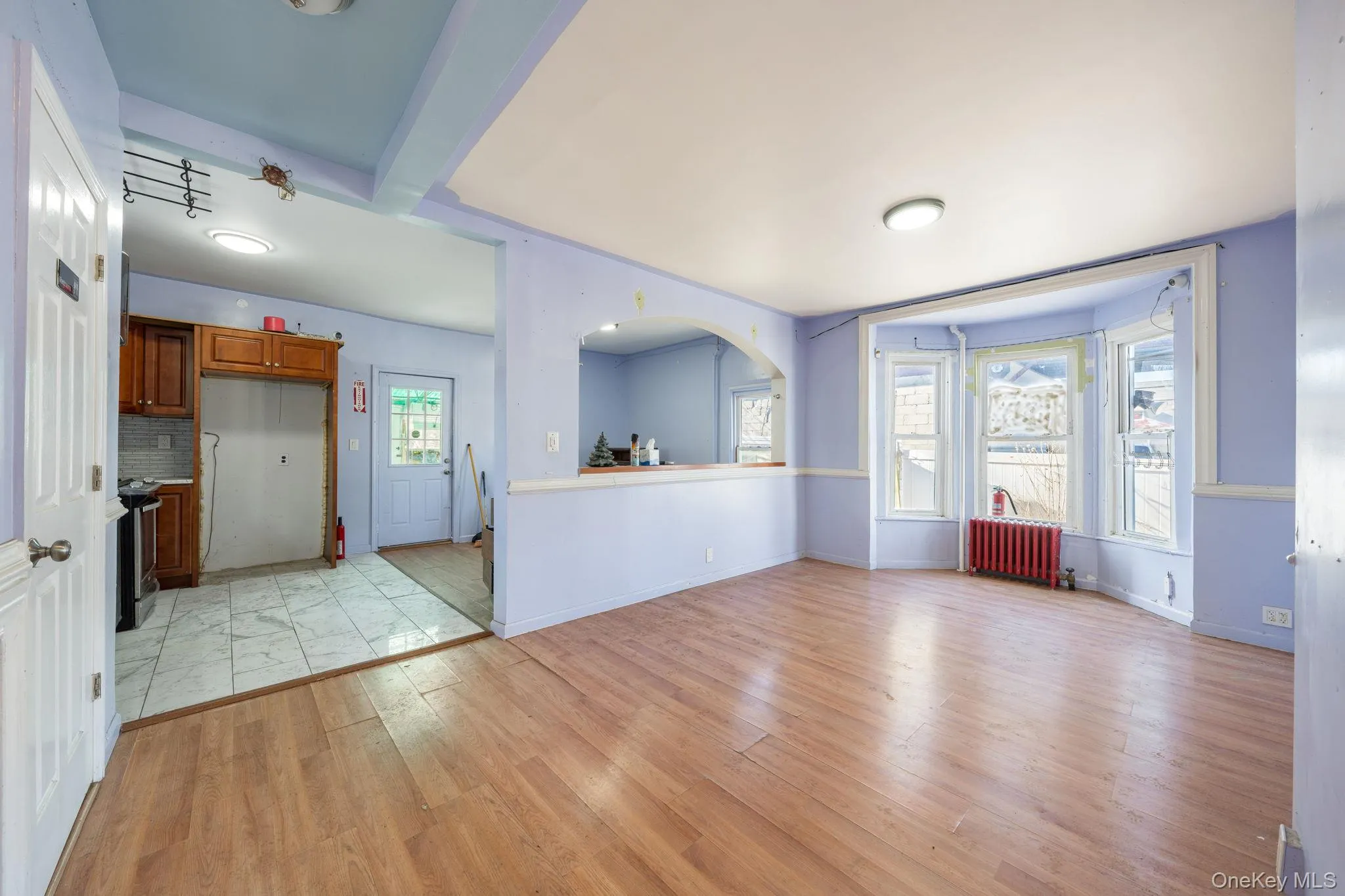 Unfurnished living room with light wood-style flooring and radiator Unfurnished living room with light wood-style flooring and radiator