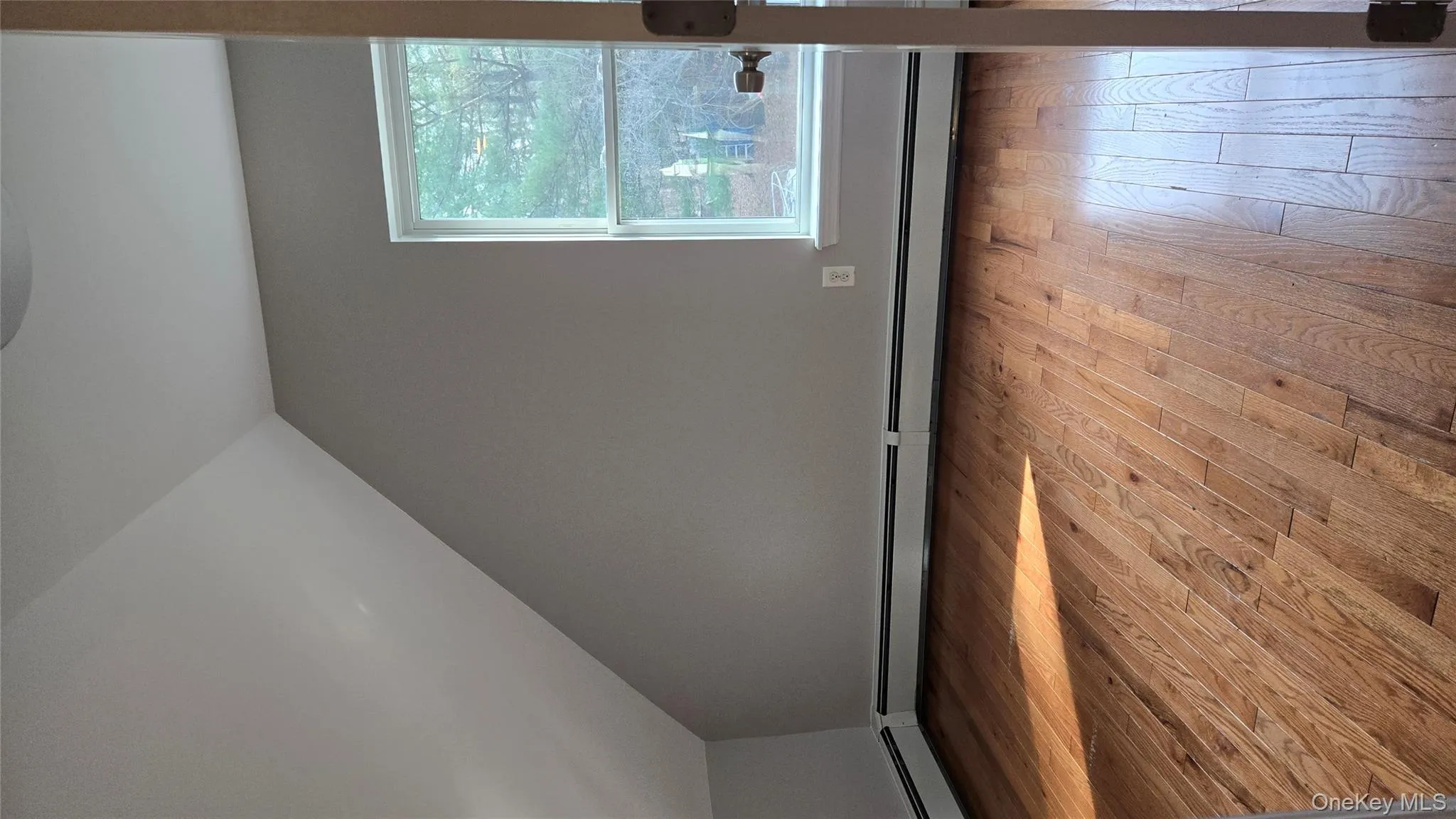 Bonus room featuring light wood finished floors, lofted ceiling, and a baseboard radiator Bonus room featuring light wood finished floors, lofted ceiling, and a baseboard radiator