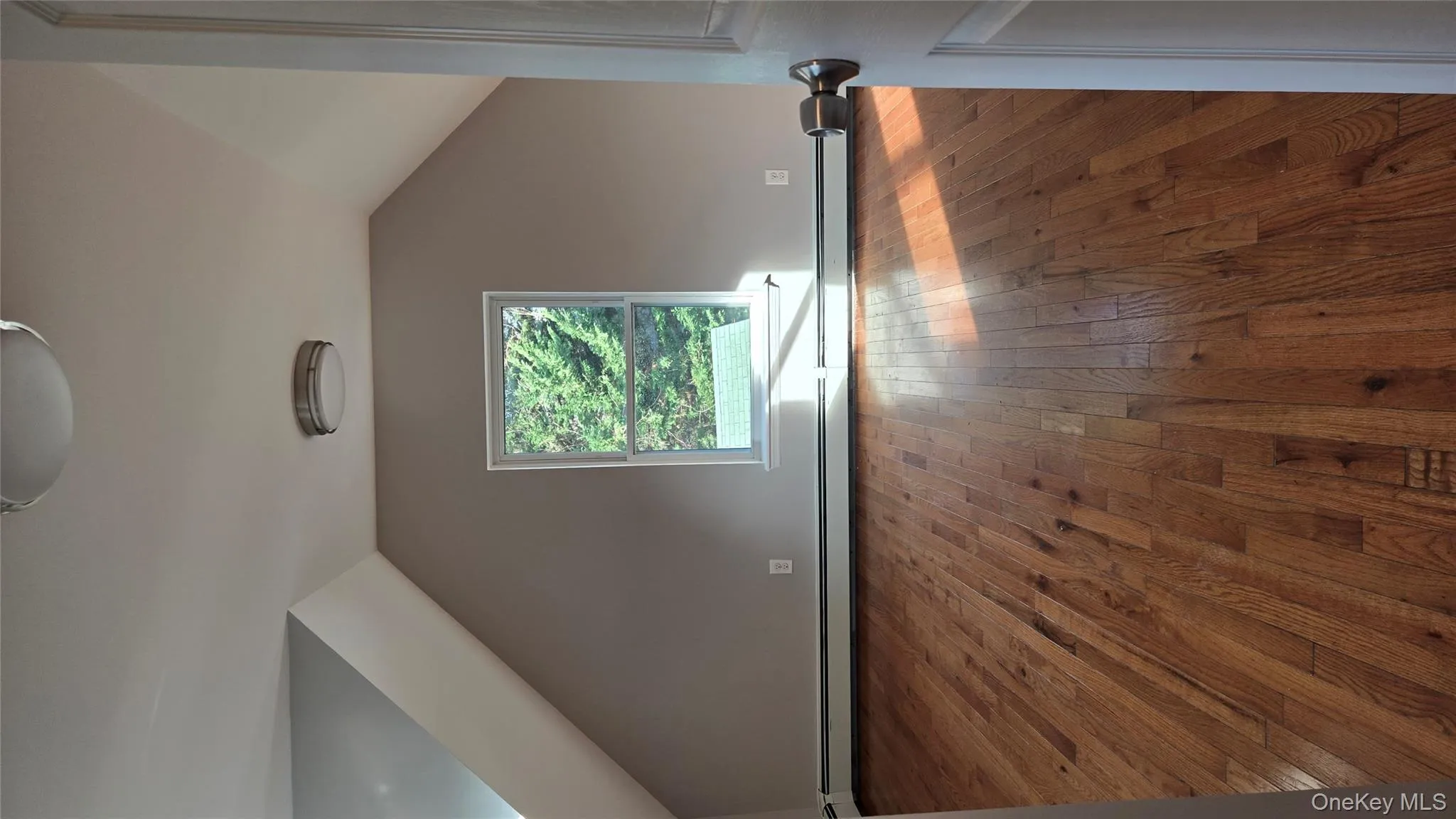 Additional living space featuring lofted ceiling, hardwood / wood-style flooring, and a baseboard heating unit Additional living space featuring lofted ceiling, hardwood / wood-style flooring, and a baseboard heating unit