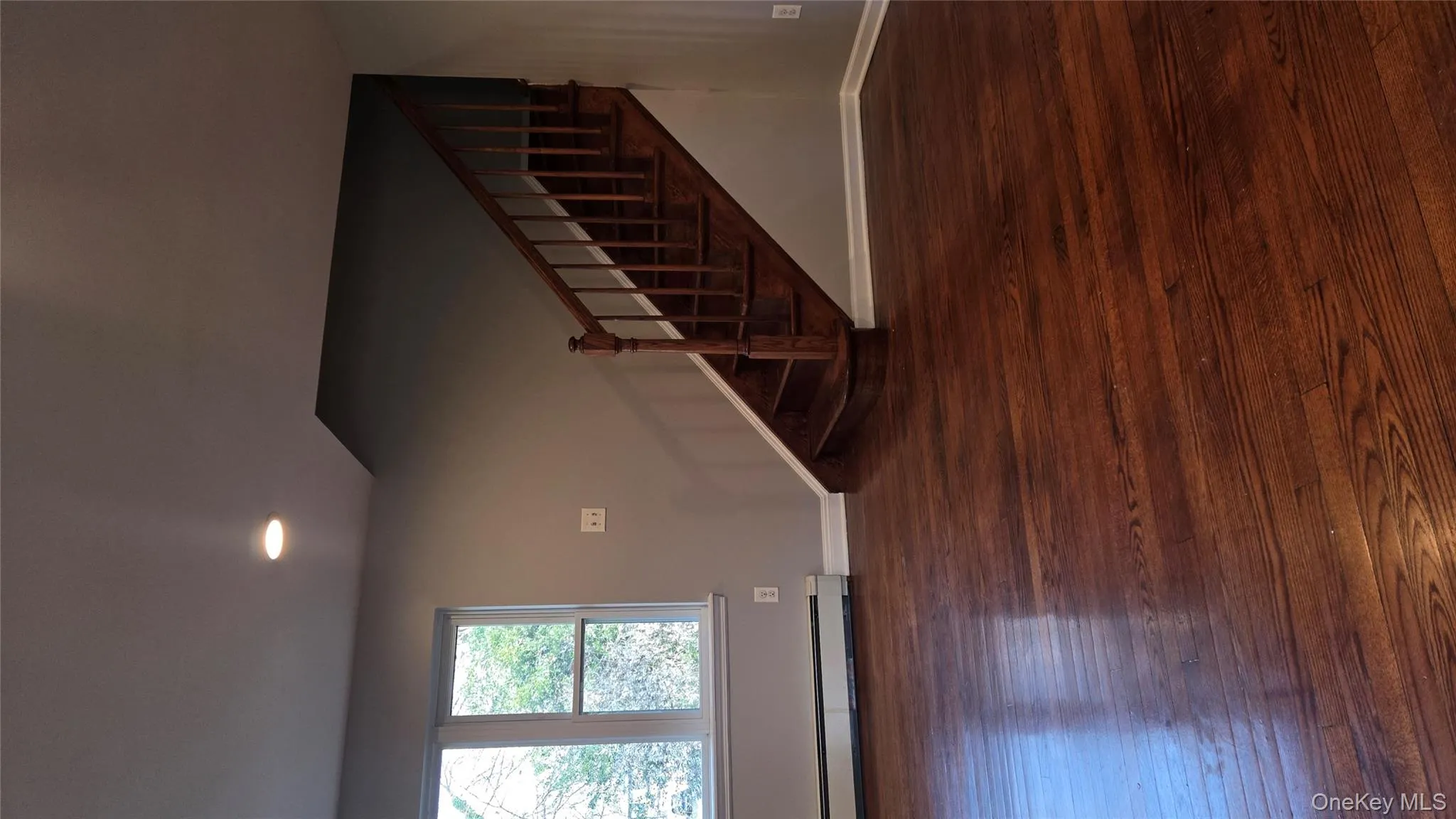 Unfurnished living room featuring stairway, dark wood-style floors, a baseboard heating unit, and recessed lighting Unfurnished living room featuring stairway, dark wood-style floors, a baseboard heating unit, and recessed lighting