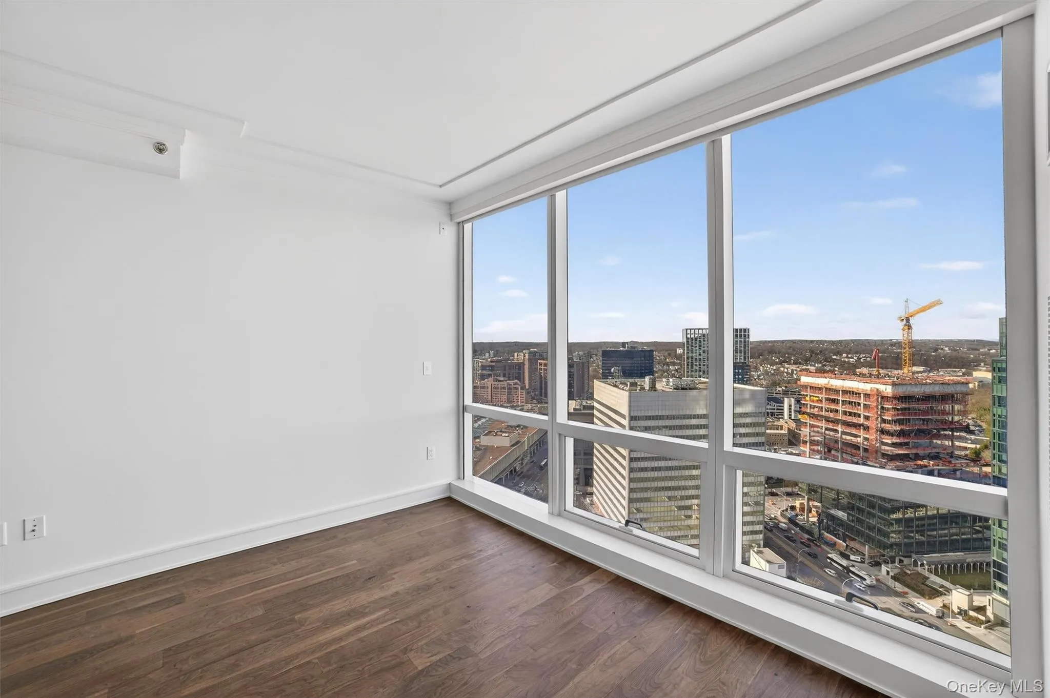 Unfurnished room featuring a city view and dark wood finished floors Unfurnished room featuring a city view and dark wood finished floors