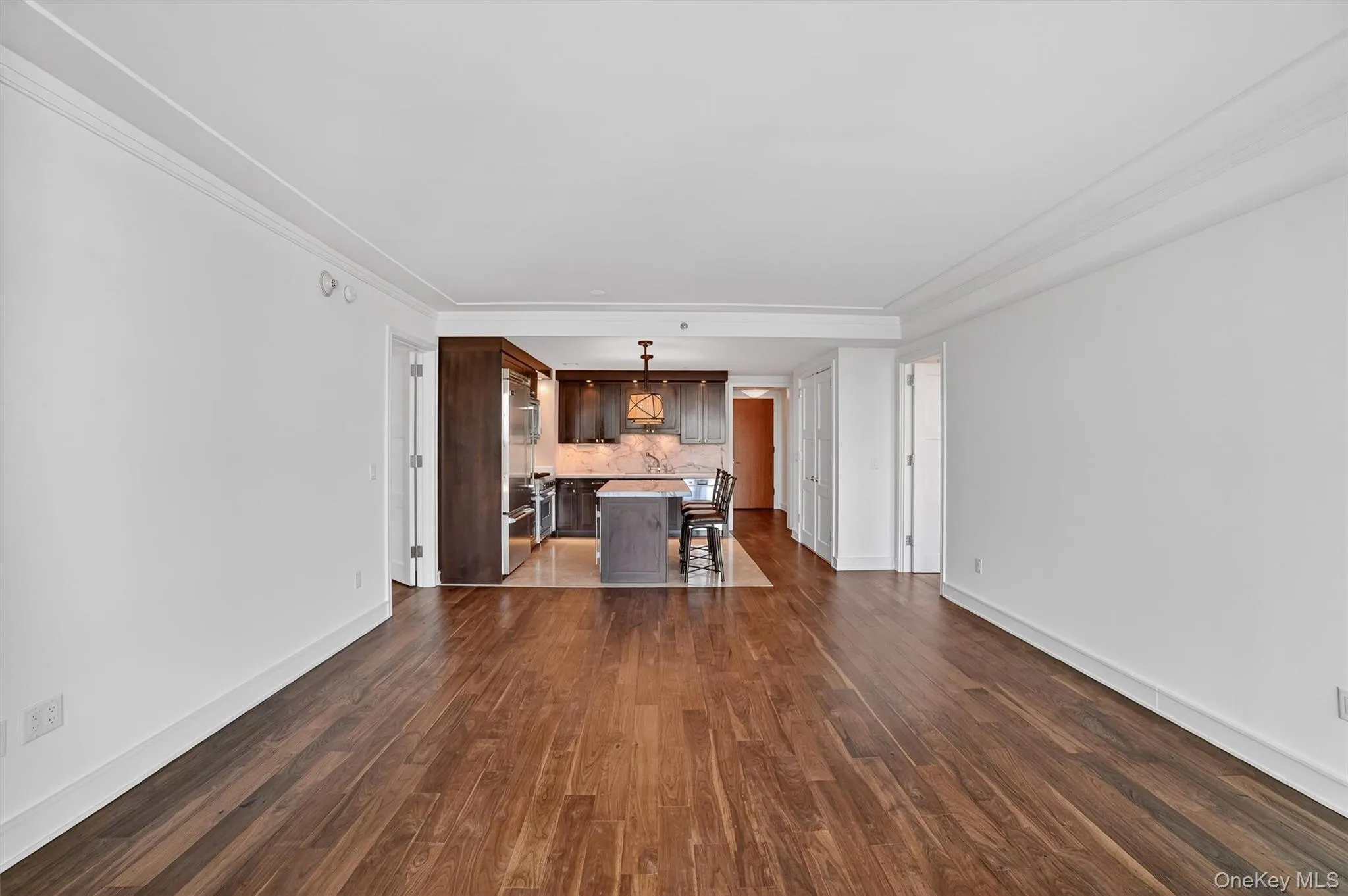 Living room with dark wood-style flooring and ornamental molding Living room with dark wood-style flooring and ornamental molding