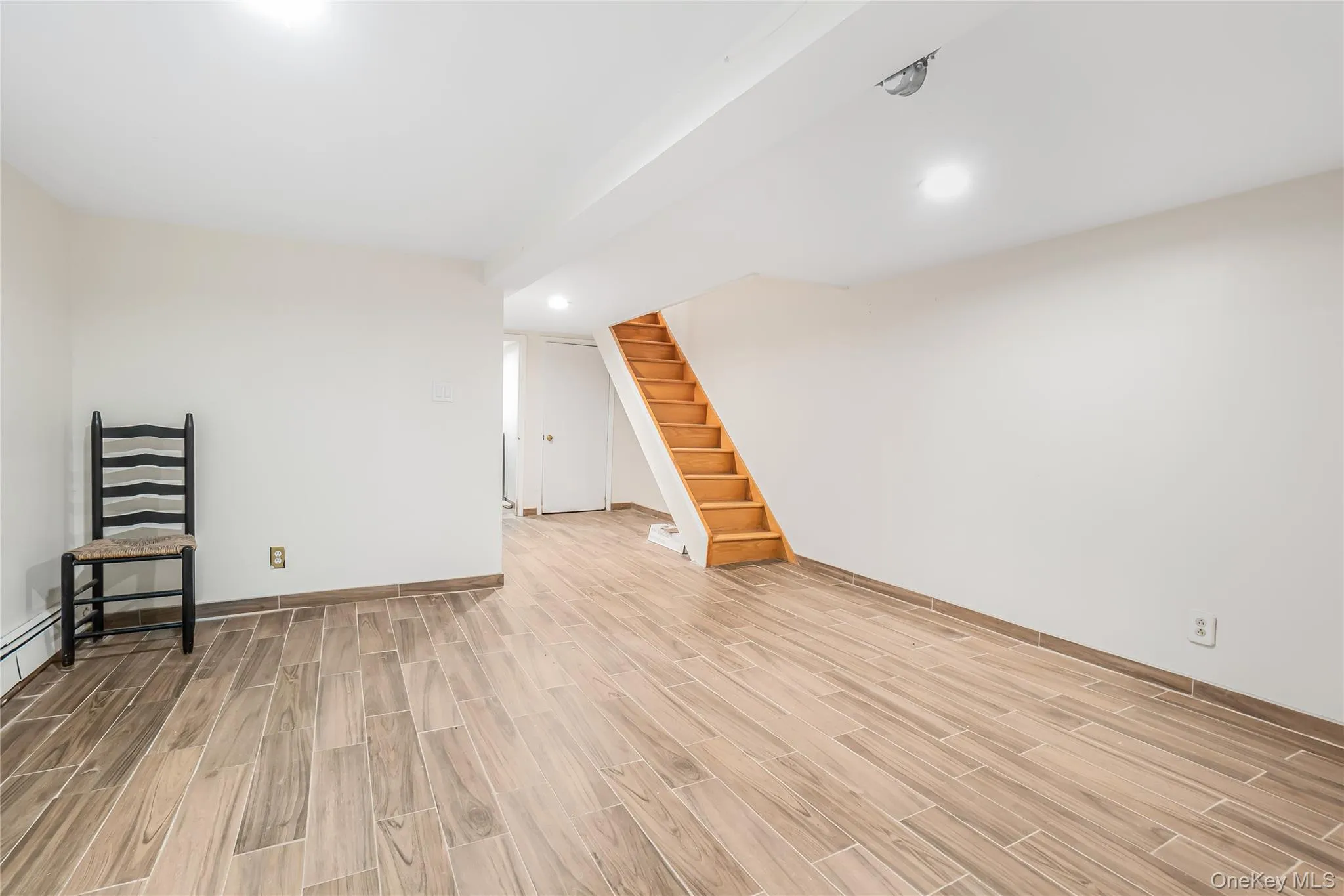 Spare room with stairway, wood finish floors, and recessed lighting Spare room with stairway, wood finish floors, and recessed lighting
