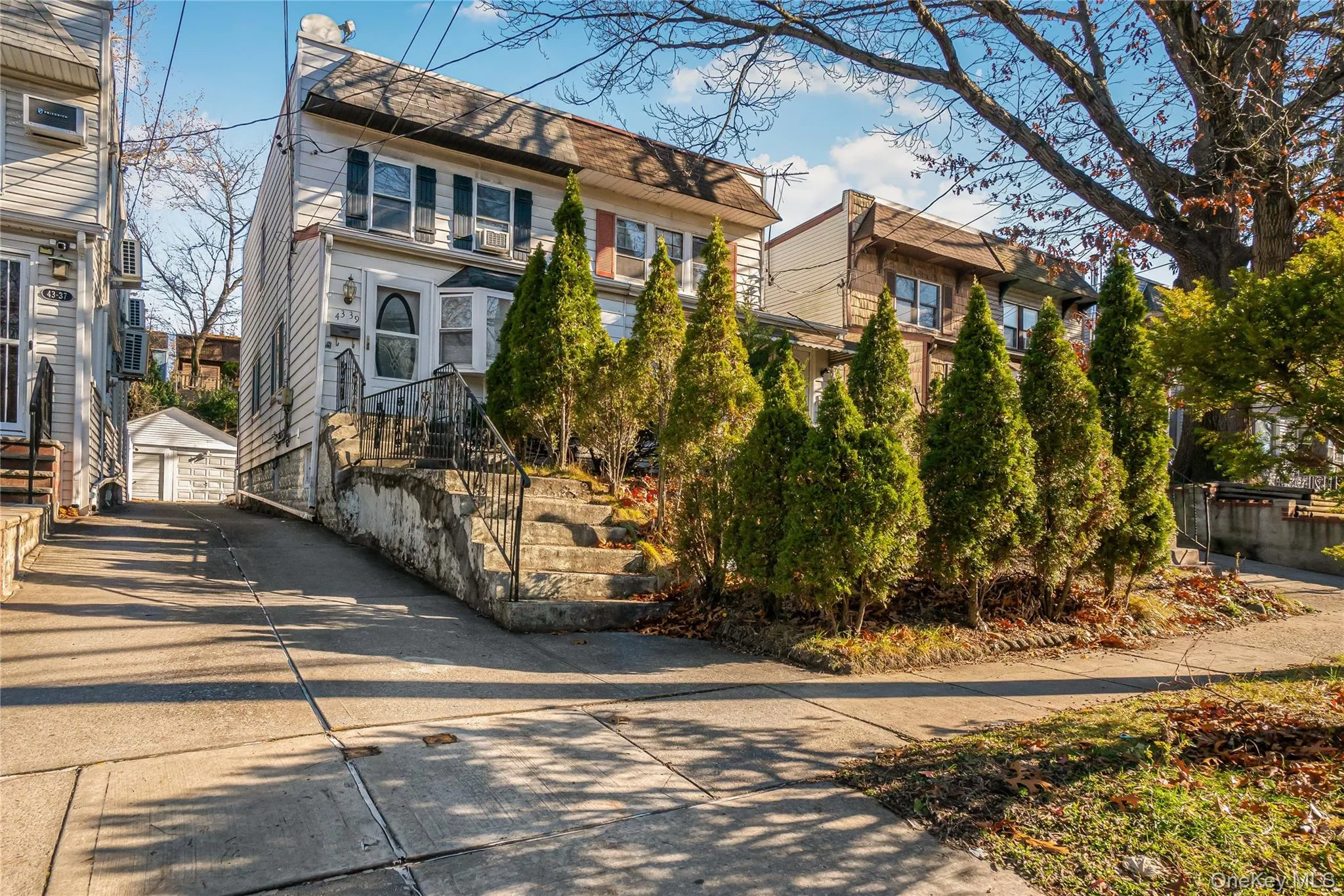 View of front of home featuring an outdoor structure, a shingled roof, mansard roof, and a detached garage View of front of home featuring an outdoor structure, a shingled roof, mansard roof, and a detached garage