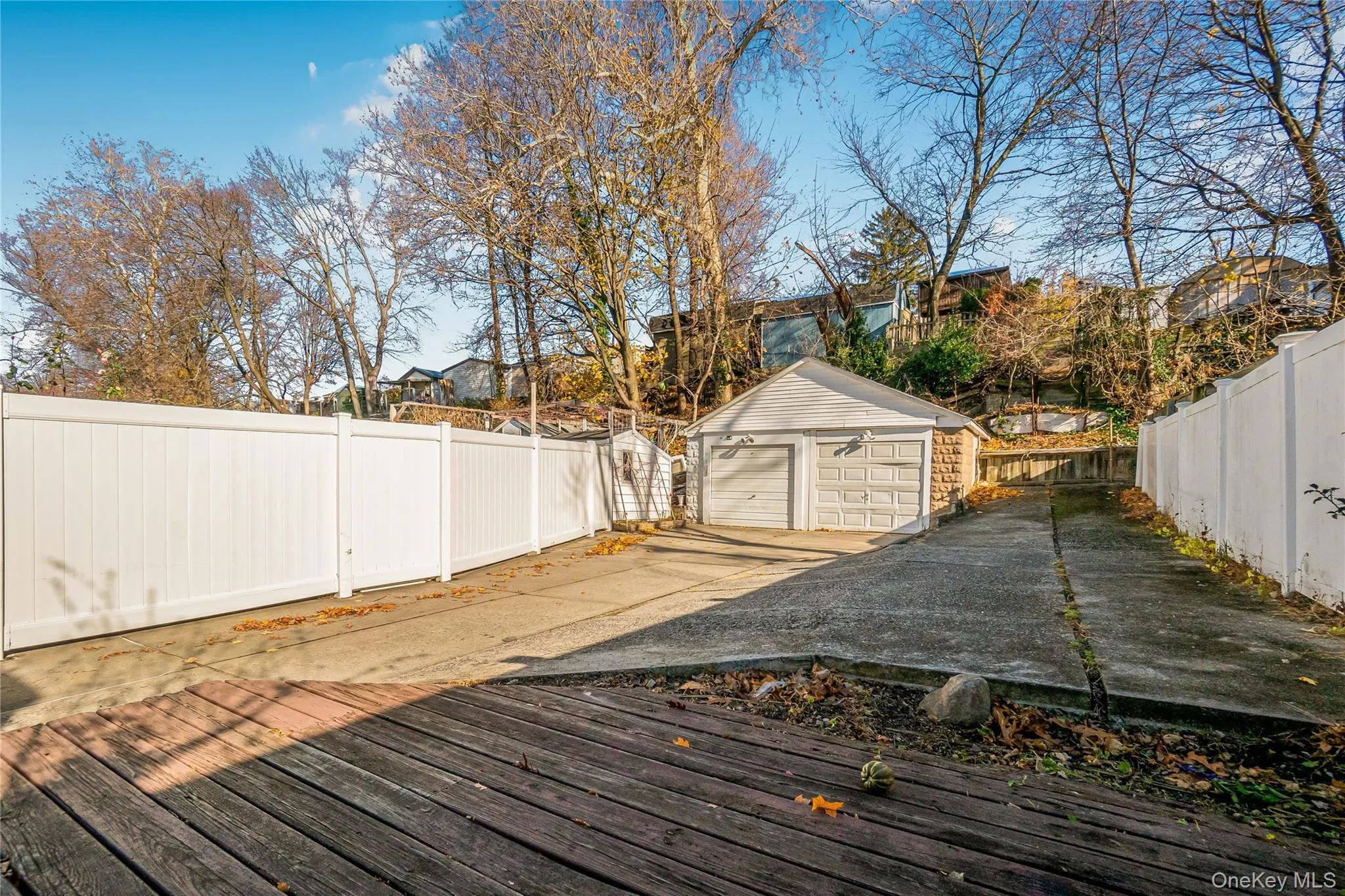 Deck with a fenced backyard, a garage, and an outbuilding Deck with a fenced backyard, a garage, and an outbuilding