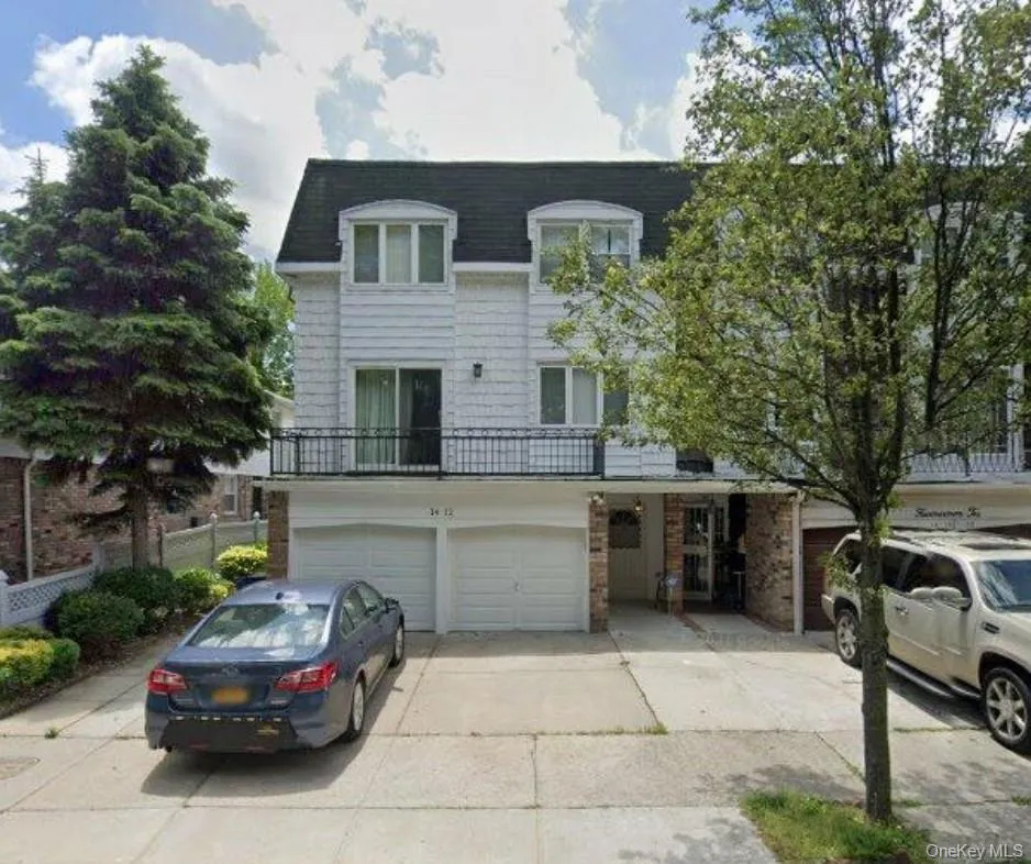 View of front of home with concrete driveway, a balcony, a shingled roof, and an attached garage View of front of home with concrete driveway, a balcony, a shingled roof, and an attached garage