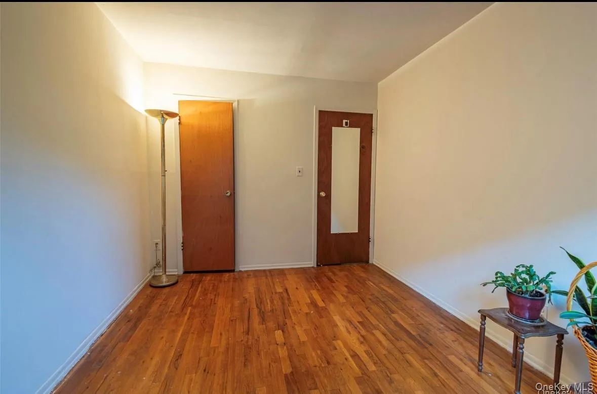 Unfurnished room featuring hardwood / wood-style flooring and baseboards Unfurnished room featuring hardwood / wood-style flooring and baseboards