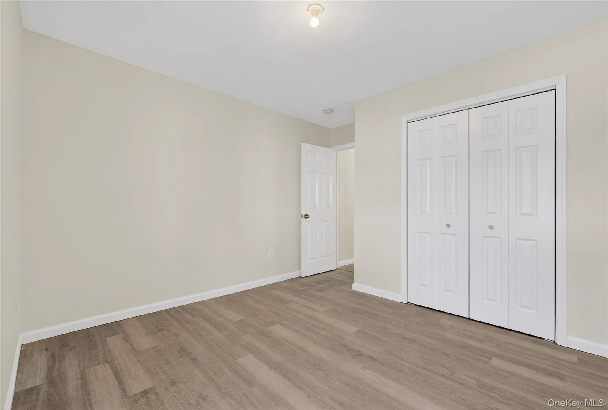 Unfurnished bedroom with a closet and light wood-type flooring Unfurnished bedroom with a closet and light wood-type flooring