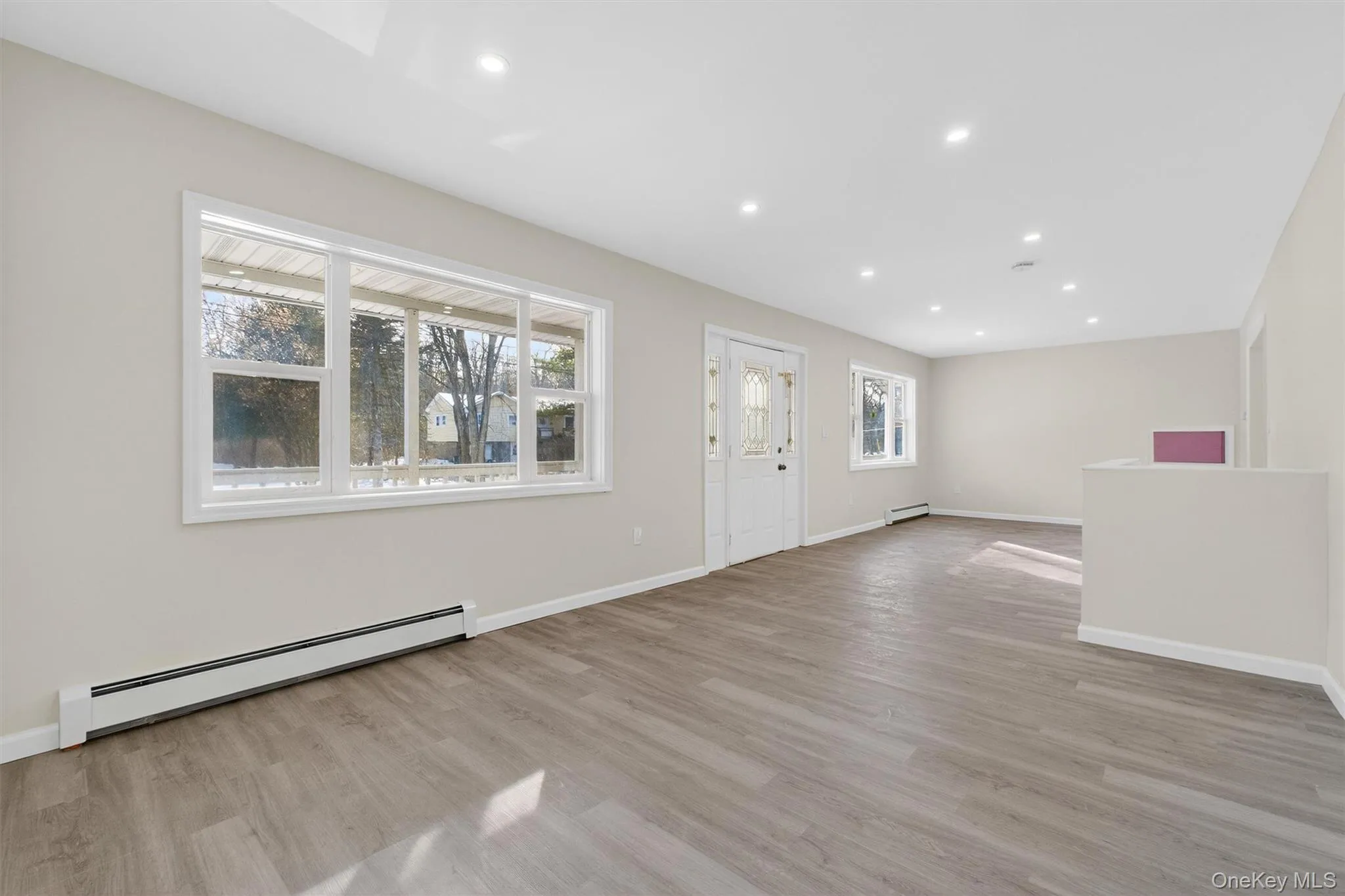 Foyer featuring a baseboard radiator, light wood-style flooring, recessed lighting, and a baseboard heating unit Foyer featuring a baseboard radiator, light wood-style flooring, recessed lighting, and a baseboard heating unit