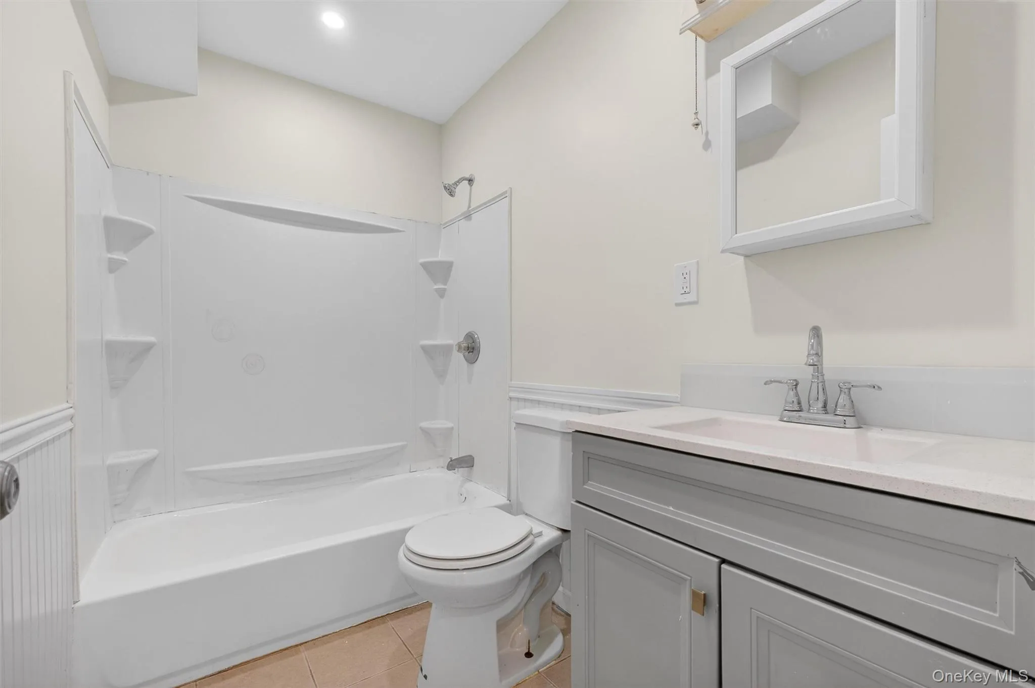 Full bathroom featuring shower / washtub combination, vanity, and light tile patterned floors Full bathroom featuring shower / washtub combination, vanity, and light tile patterned floors