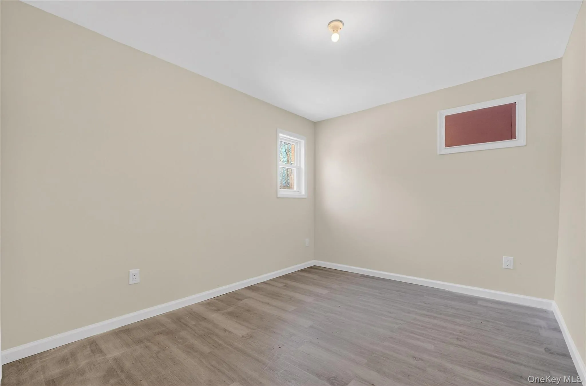 Spare room with wood finished floors and baseboards Spare room with wood finished floors and baseboards
