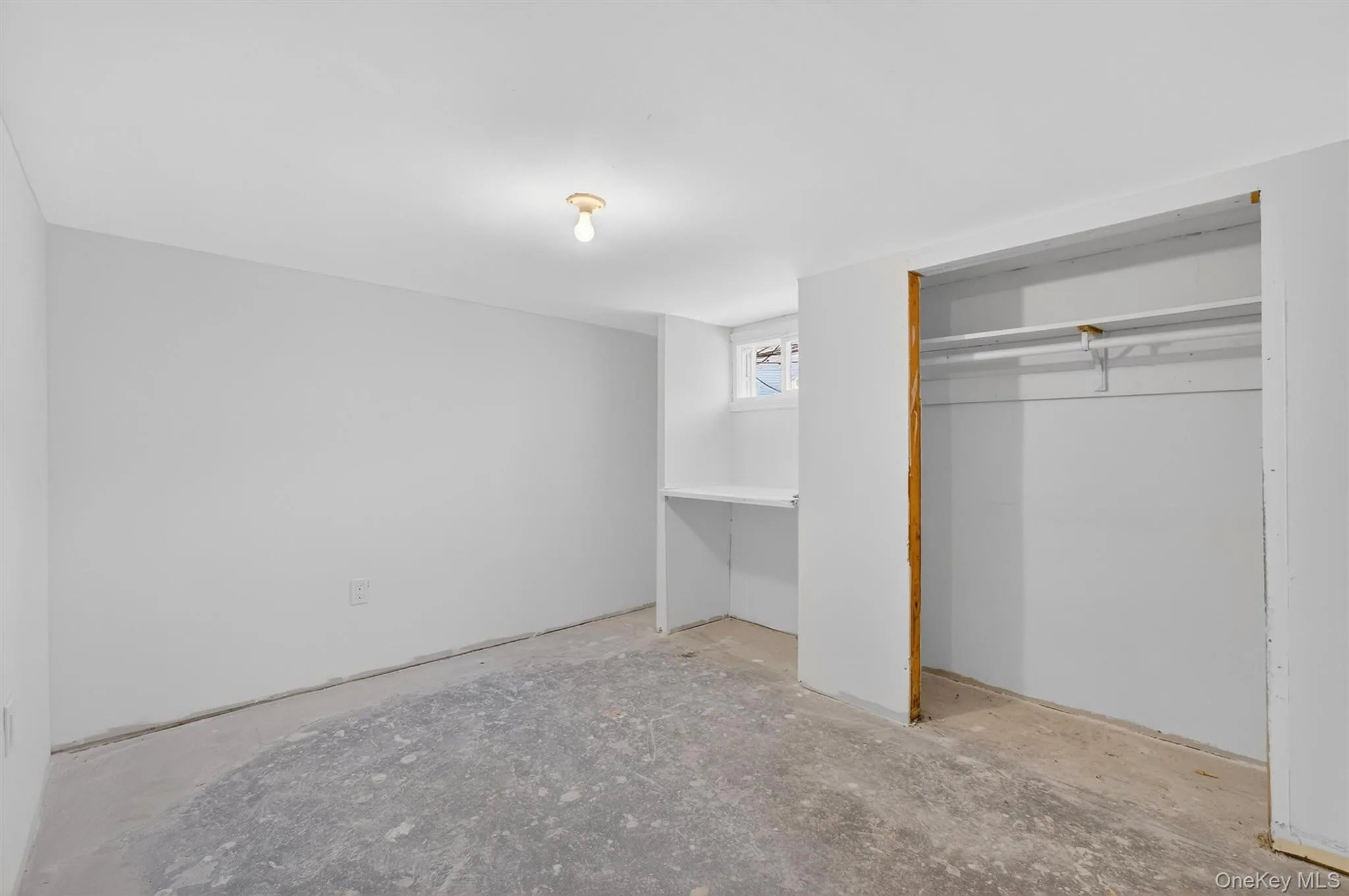 Unfurnished bedroom with unfinished concrete flooring Unfurnished bedroom with unfinished concrete flooring