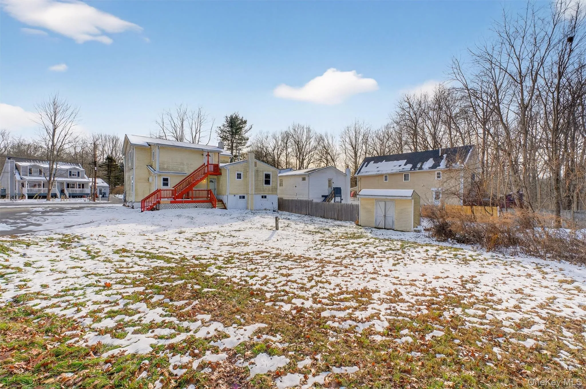 Snow covered back of property with a storage shed Snow covered back of property with a storage shed