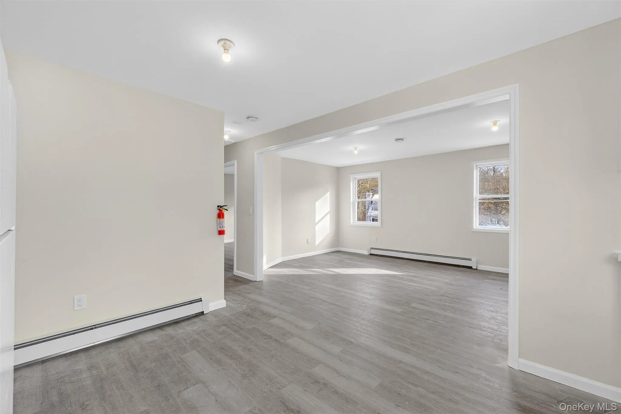 Empty room featuring a baseboard radiator and light wood-style flooring Empty room featuring a baseboard radiator and light wood-style flooring