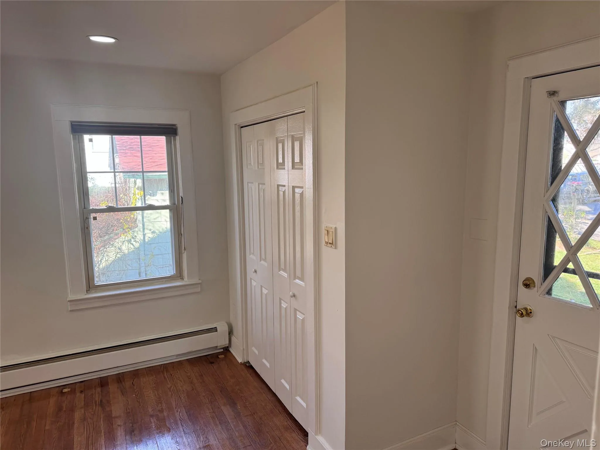 Entryway with a baseboard radiator, dark wood-type flooring, and recessed lighting Entryway with a baseboard radiator, dark wood-type flooring, and recessed lighting