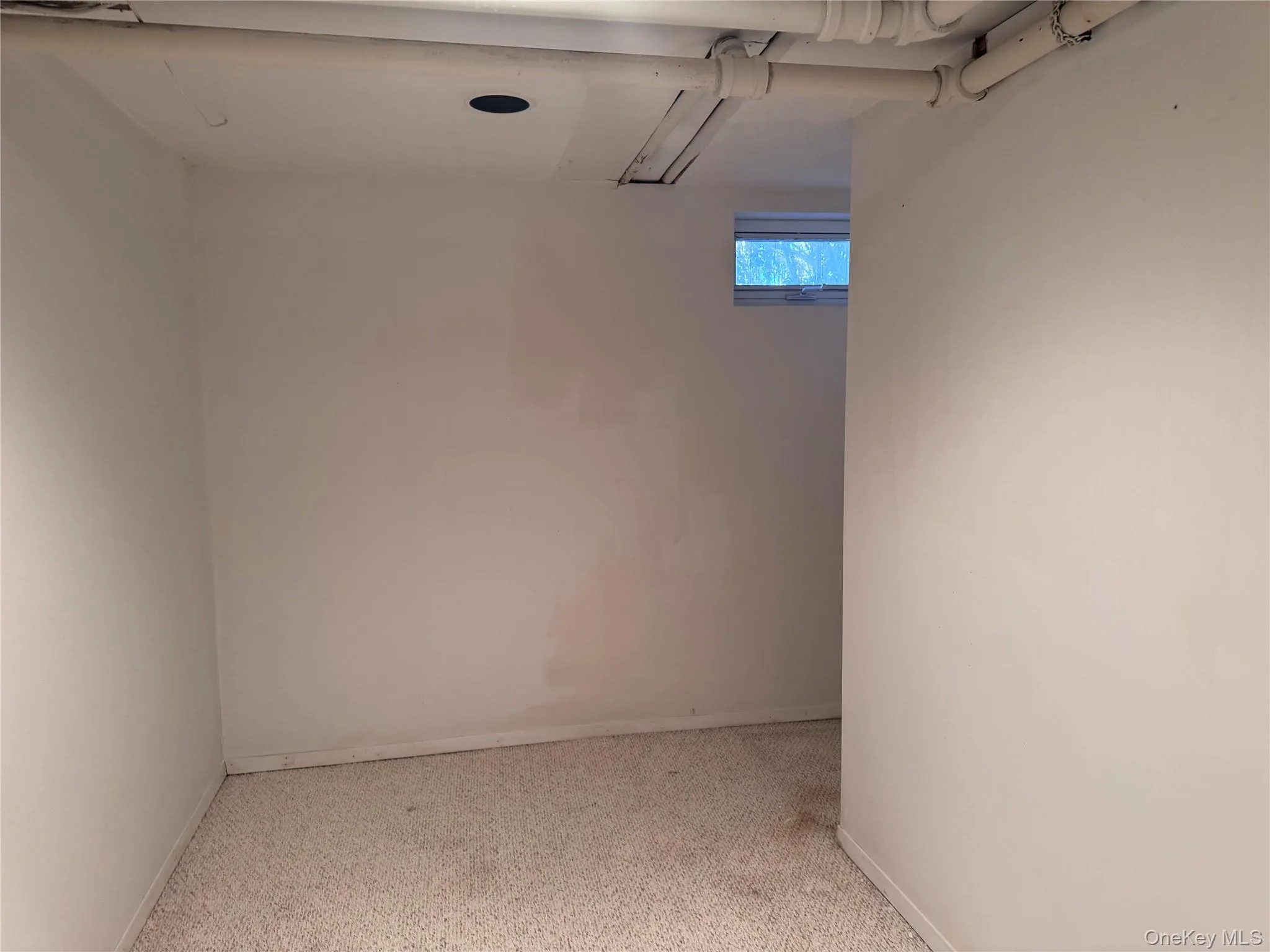 Below grade area featuring baseboards and light carpet Below grade area featuring baseboards and light carpet