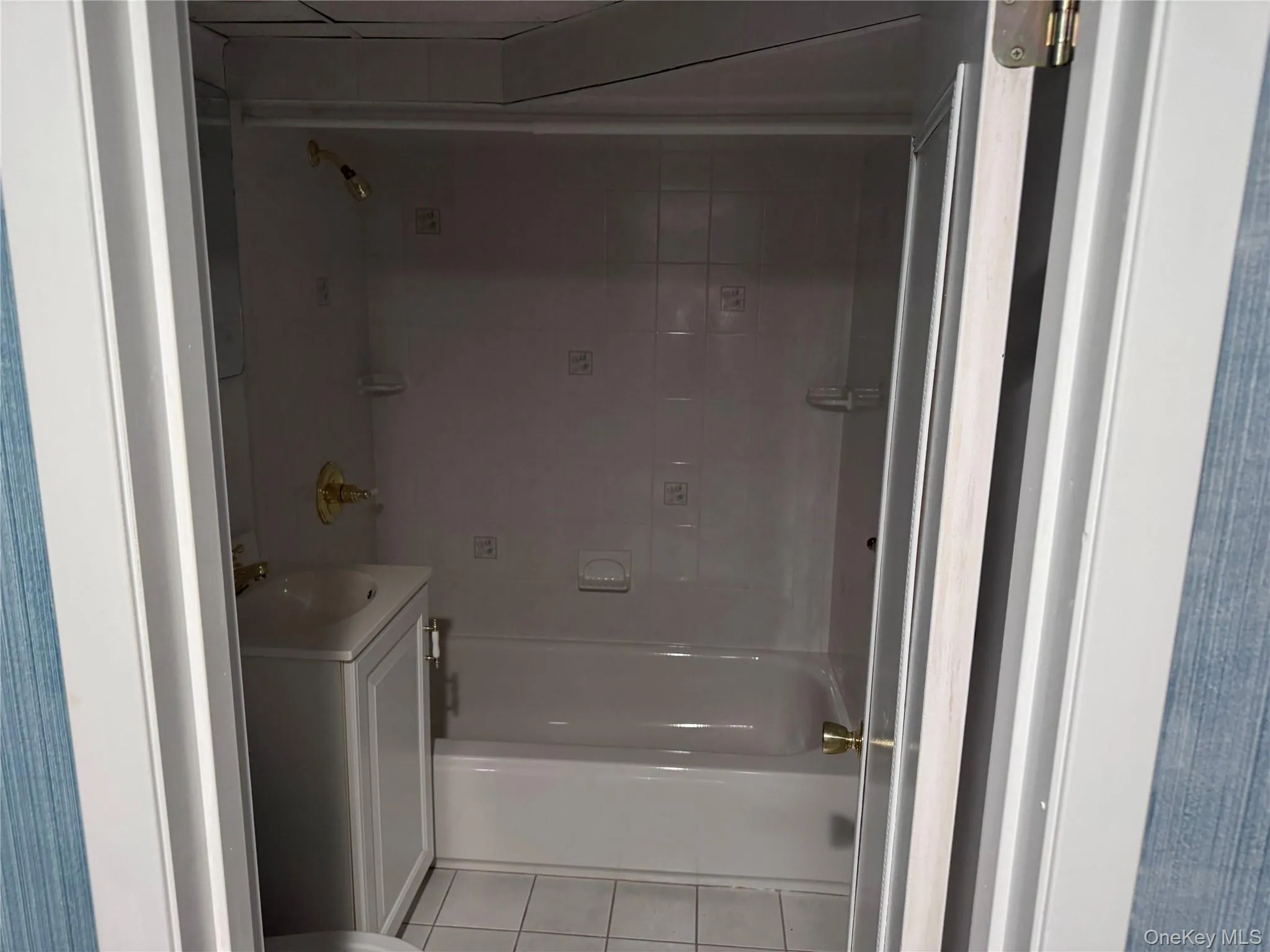 Full bathroom featuring shower / bathtub combination, vanity, and light tile patterned flooring Full bathroom featuring shower / bathtub combination, vanity, and light tile patterned flooring