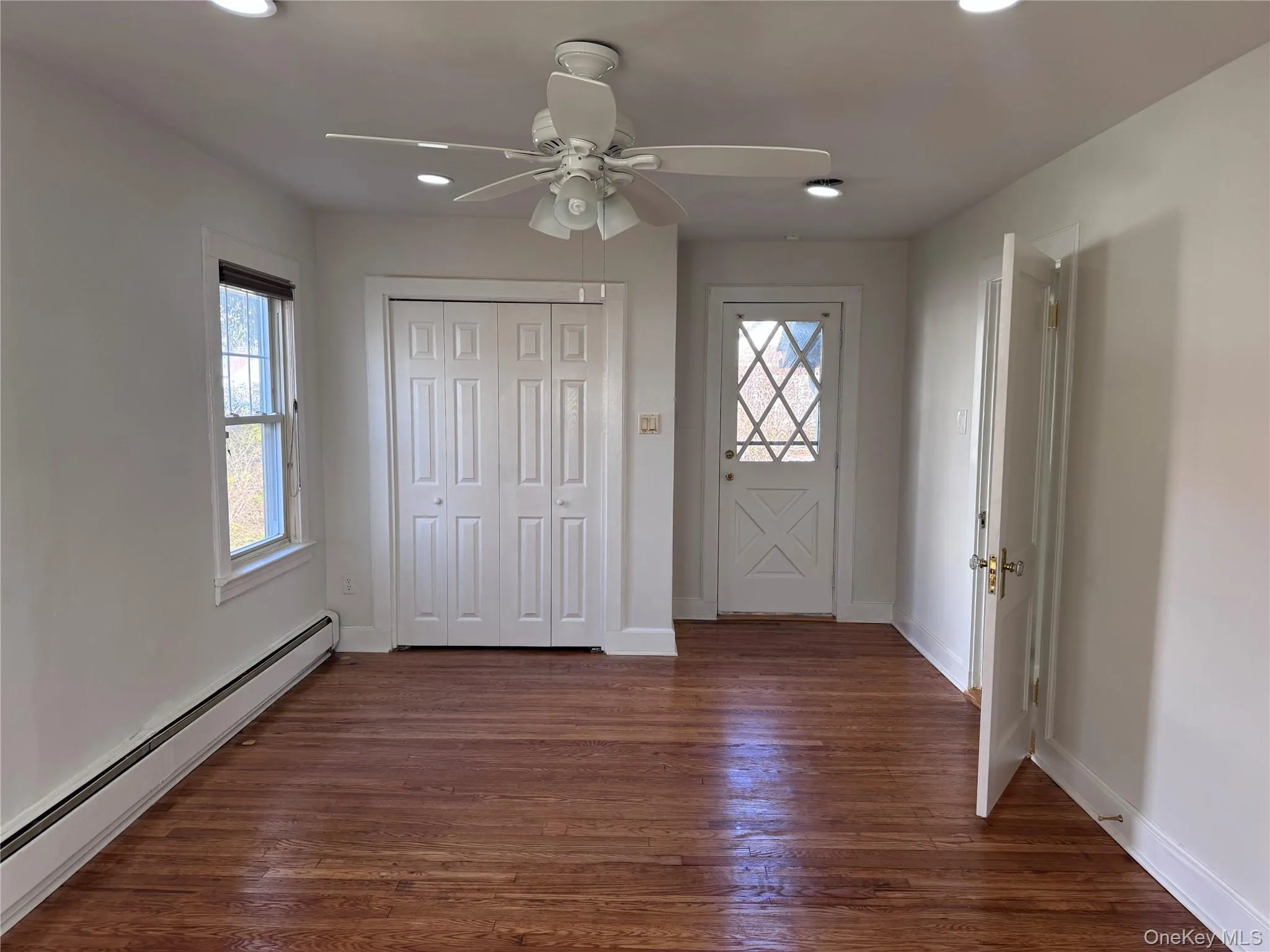 Entrance foyer featuring a baseboard heating unit, dark wood-type flooring, recessed lighting, and a ceiling fan Entrance foyer featuring a baseboard heating unit, dark wood-type flooring, recessed lighting, and a ceiling fan