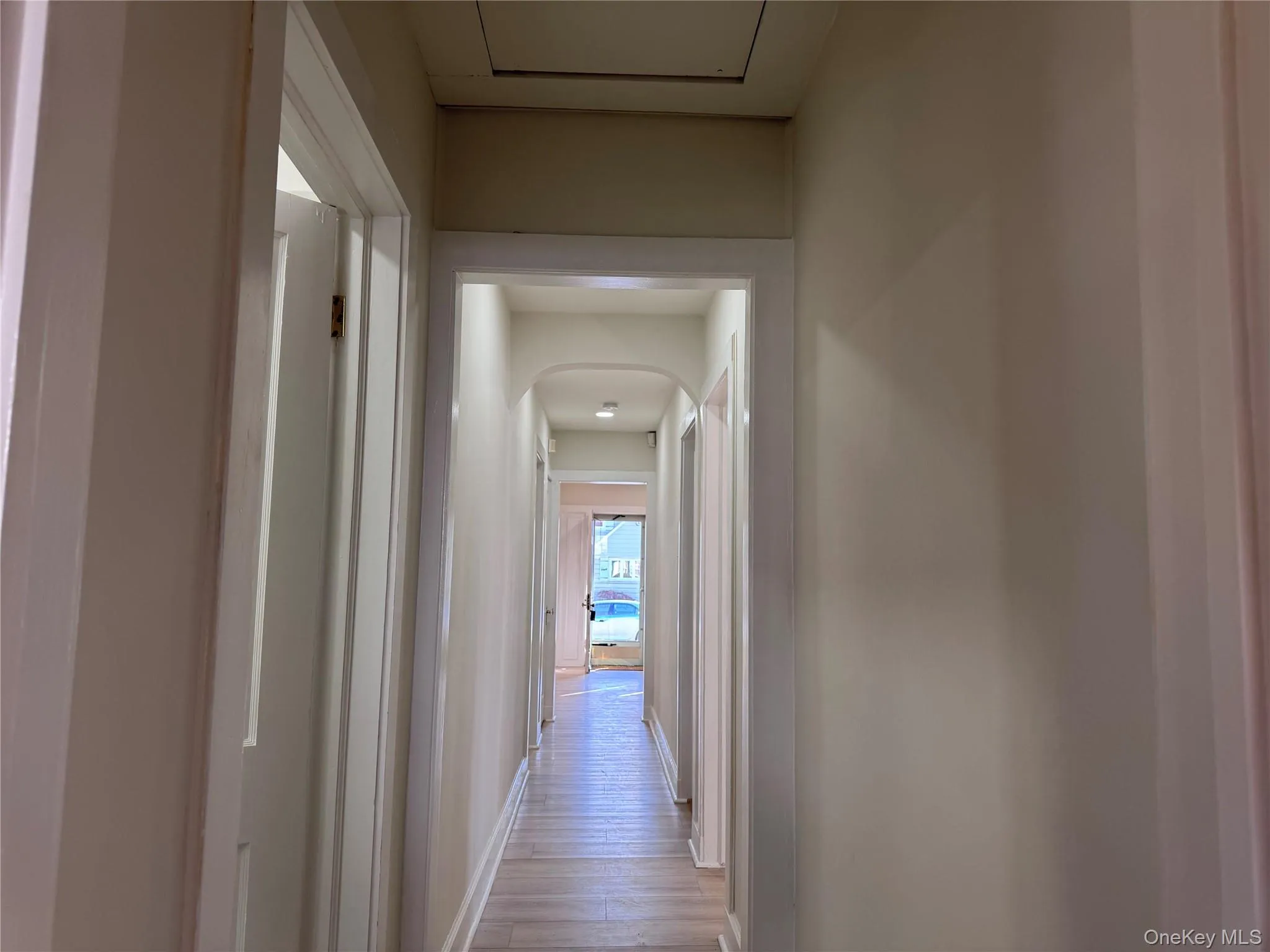 Hall featuring arched walkways and wood finished floors Hall featuring arched walkways and wood finished floors